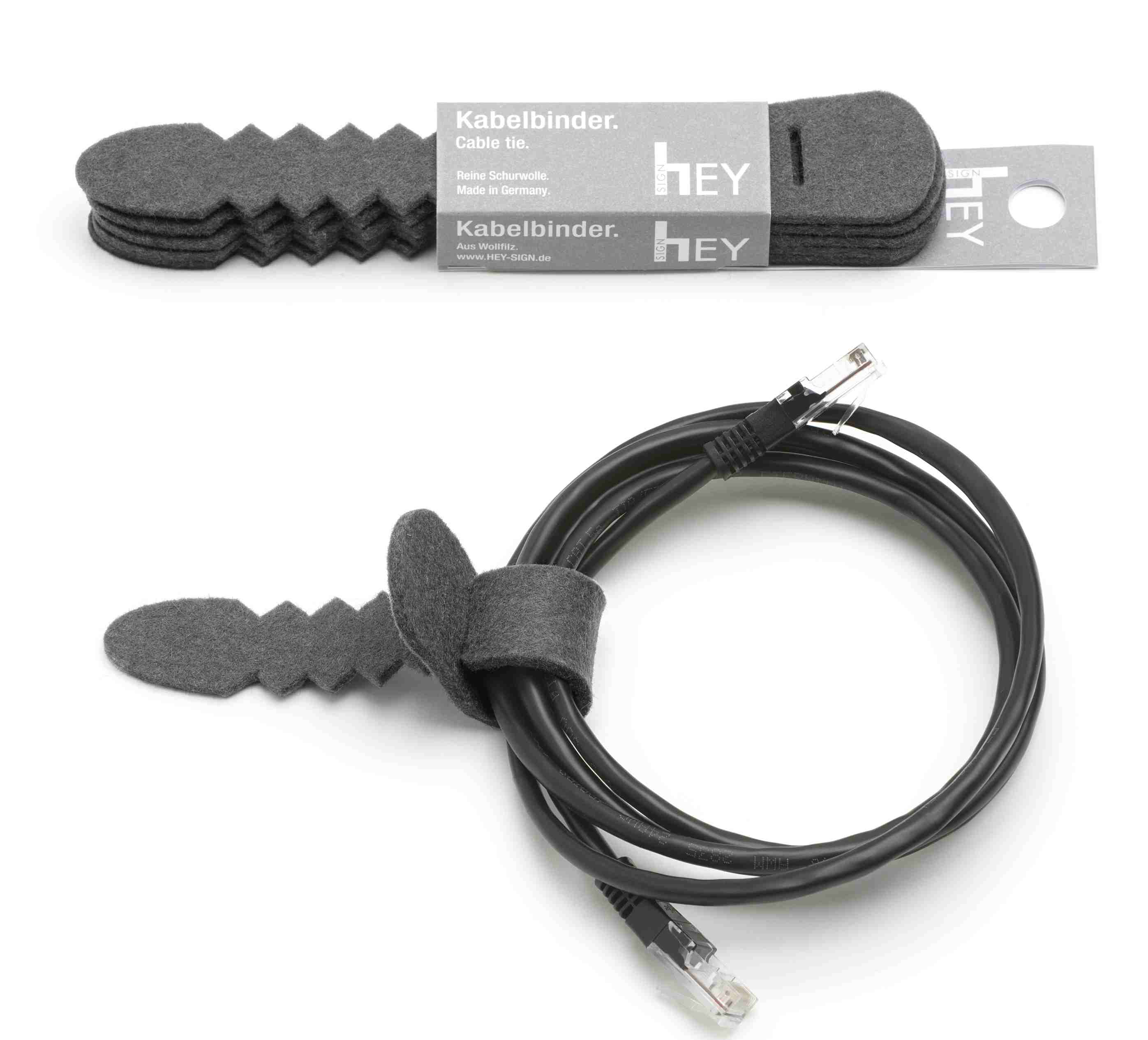 Anthrazitfarbener Hey Sign Kabelbinder aus Filz, der ein schwarzes Kabel ordentlich zusammenhält.