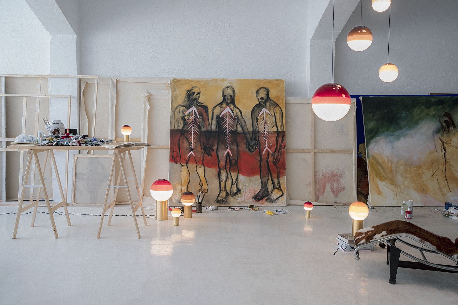 Dipping Light Pendelleuchten und Tischleuchten von Marset in einem hellen Atelier mit Kunst.
