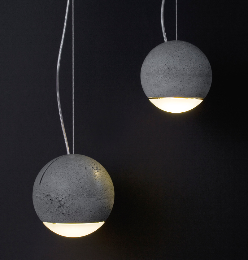 Zwei graue Trabant Pendelleuchten von Tecnolumen mit runden Lampenschirmen aus Beton und warmweißem Licht.