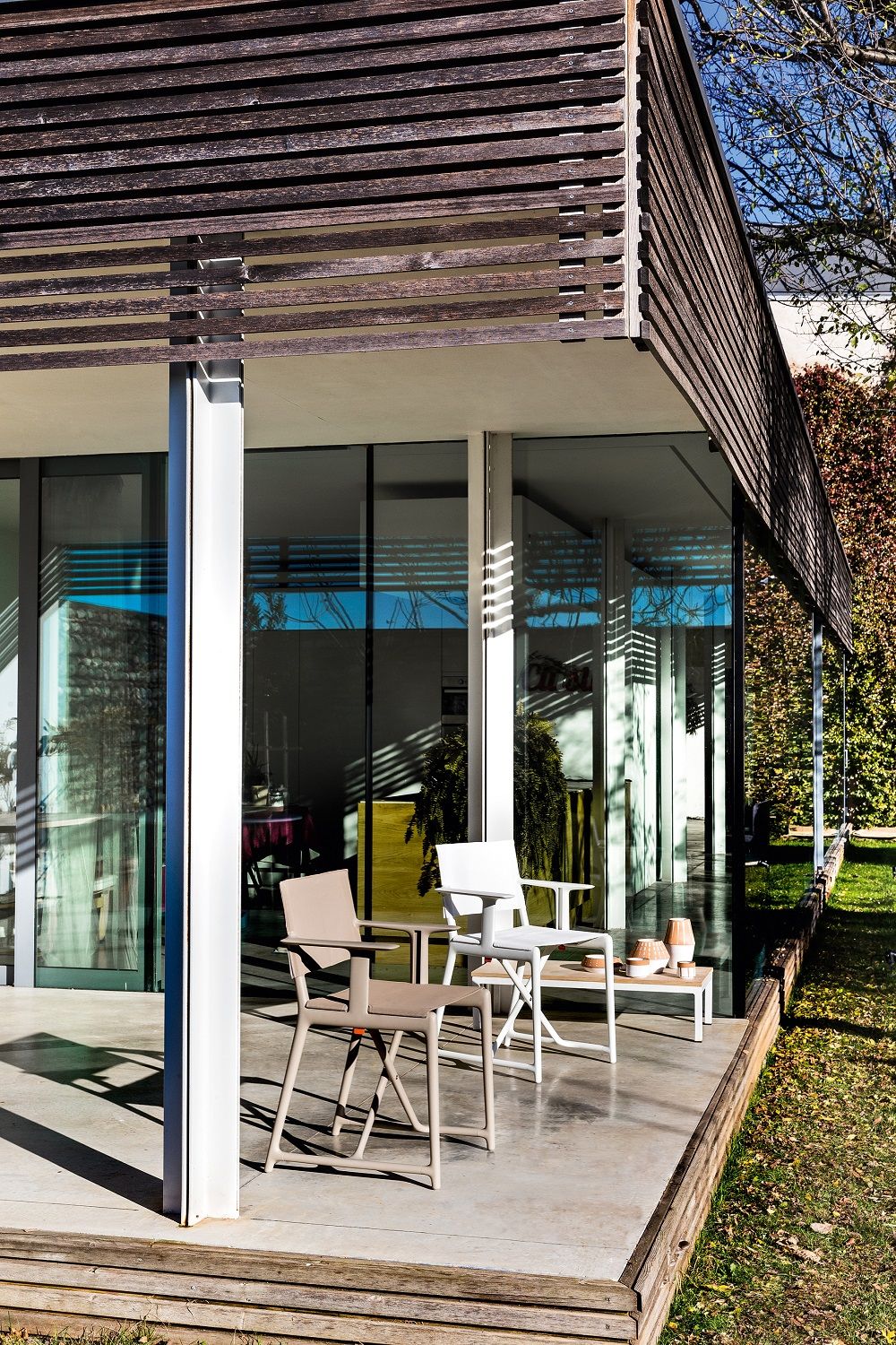 Zwei Stanley Regiestühle von Magis im Außenbereich vor einem modernen Haus.