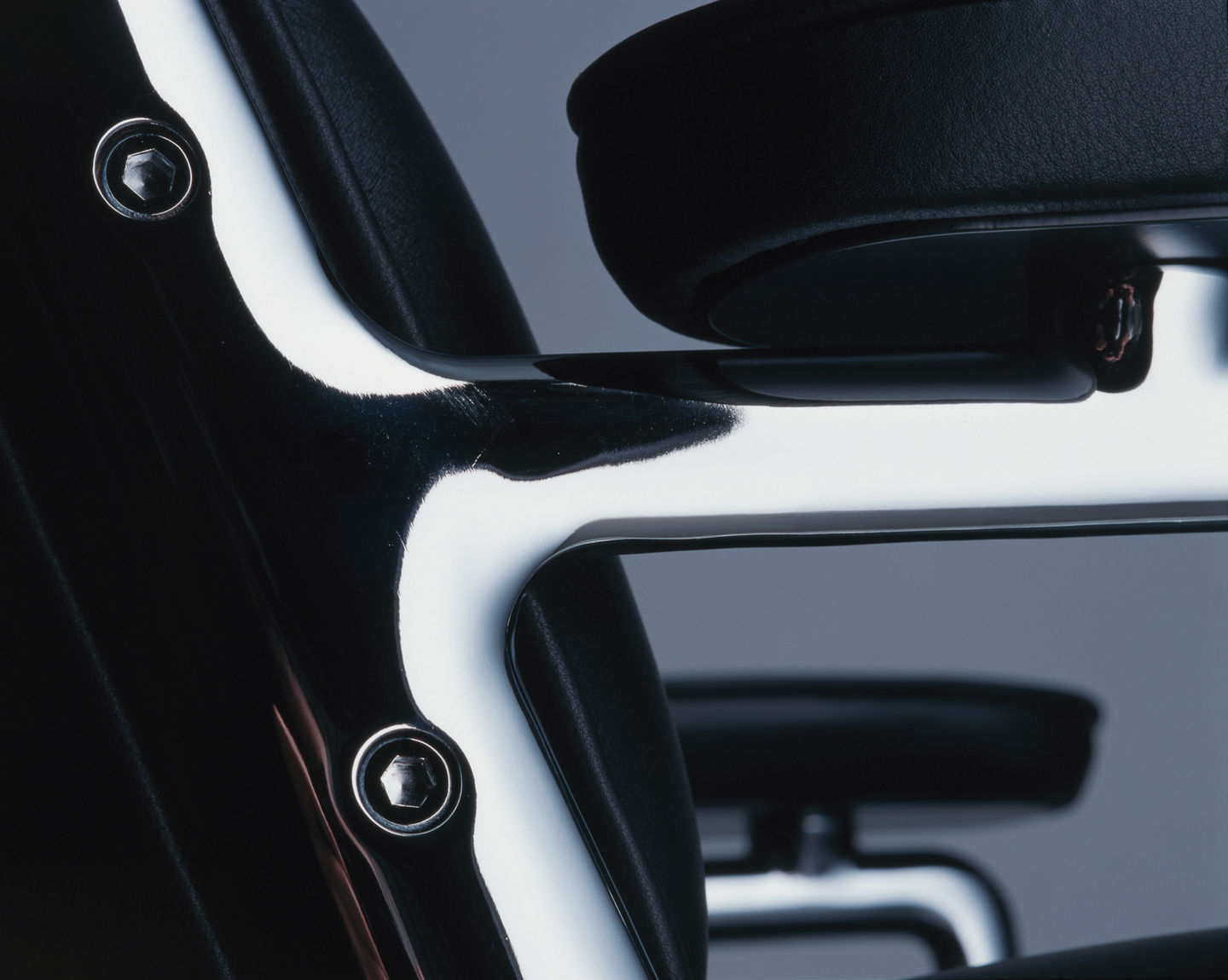 Detailaufnahme des Vitra Lobby Chair ES 105 Stuhls mit schwarzem Leder und Chromgestell.