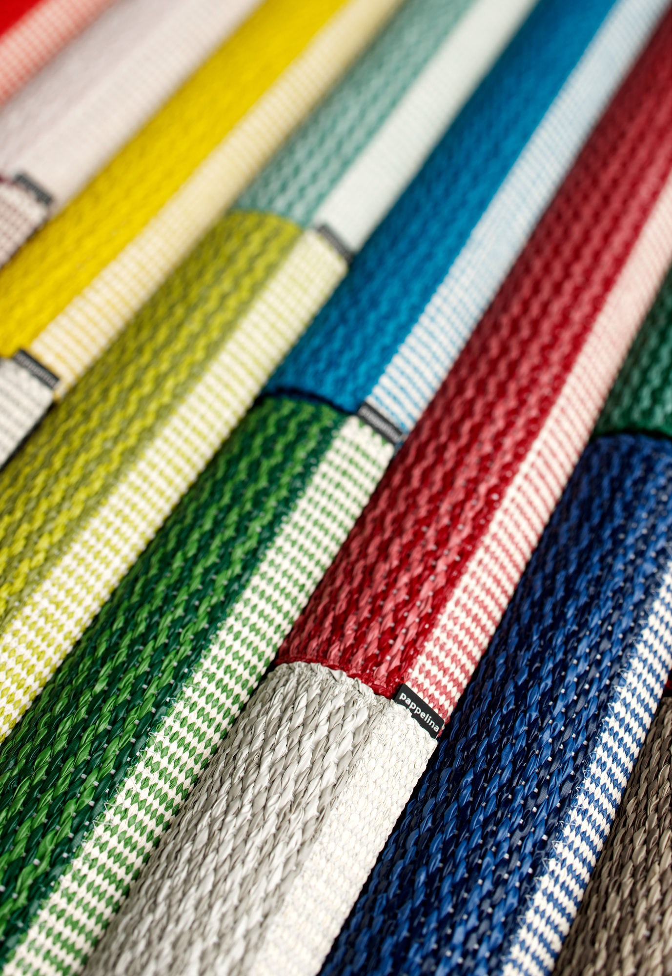 Detailaufnahme verschiedenfarbiger Pappelina Kunststoffteppiche, z.B. Mono Teppich, gewebt mit Muster. Geeignet für Innen- und Außenbereich.