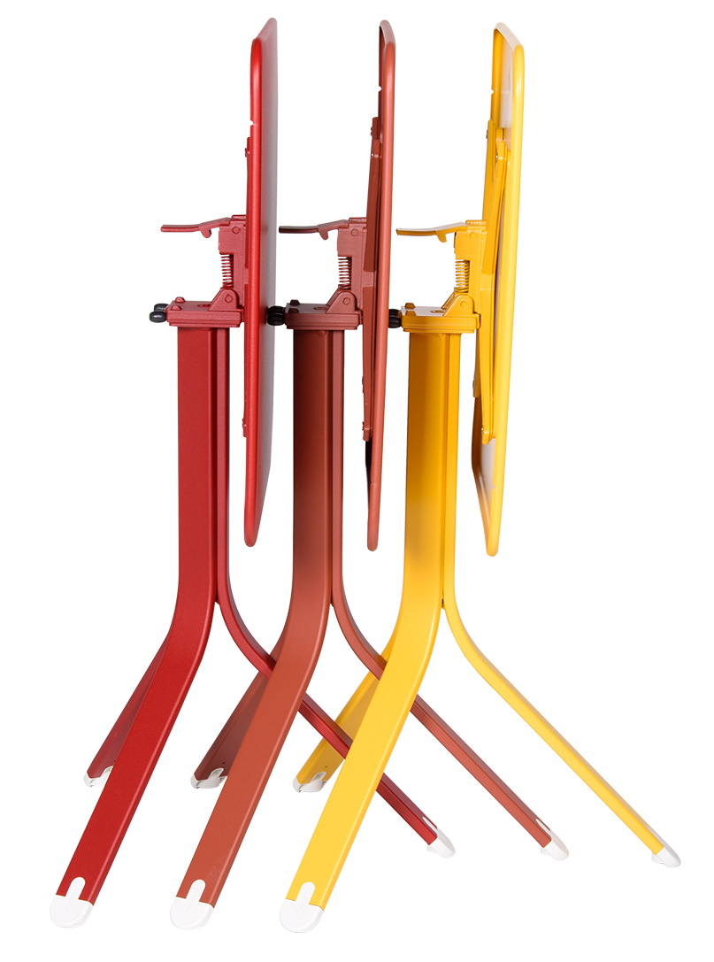 Drei Fermob Rest'O Tische in Rot, Braun und Gelb, zusammengeklappt, für den Outdoor-Bereich.