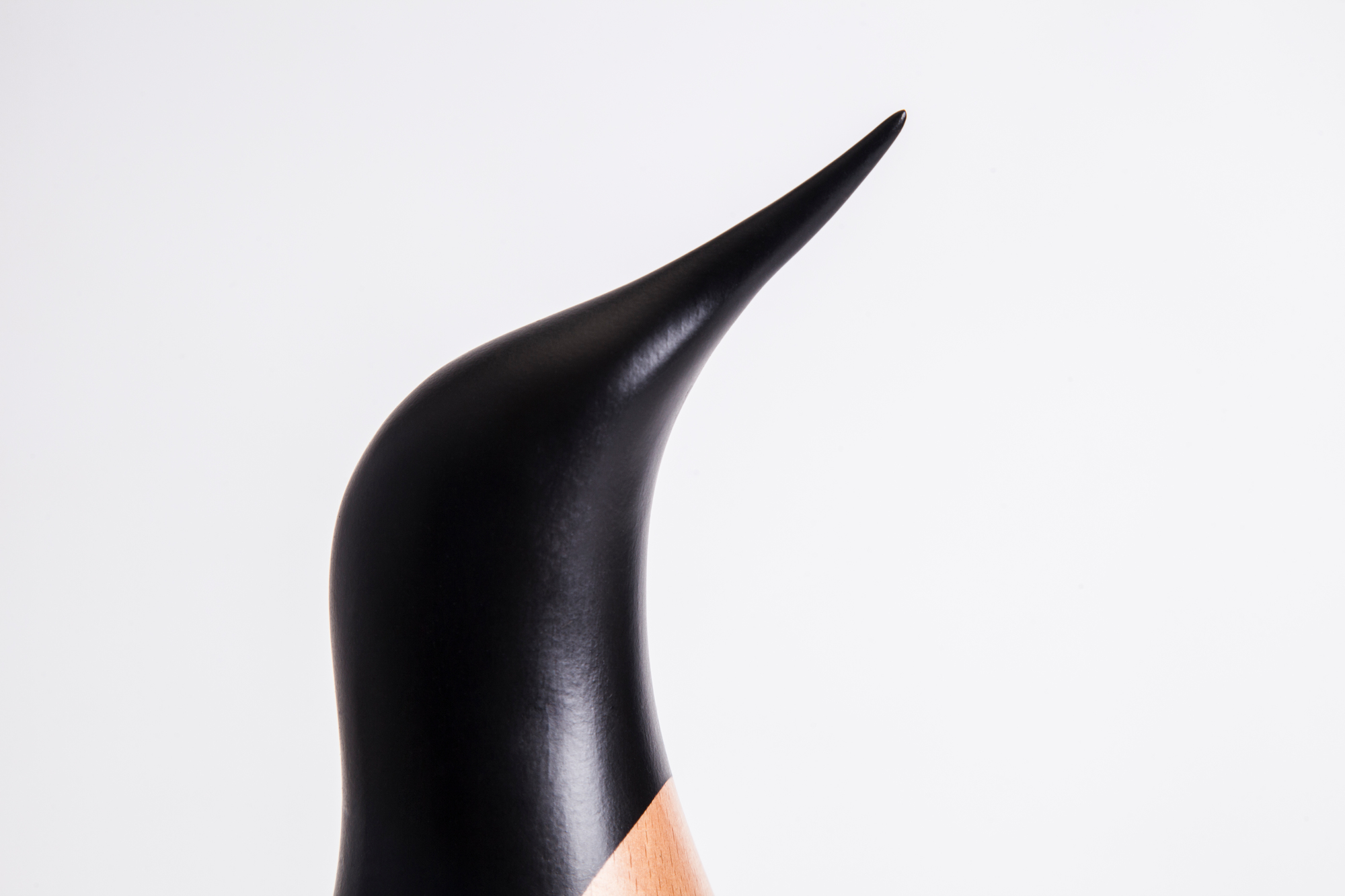 Detailaufnahme des Kopfes der Architectmade Pinguin Holzfigur, handgefertigte Dekoration für Zuhause.