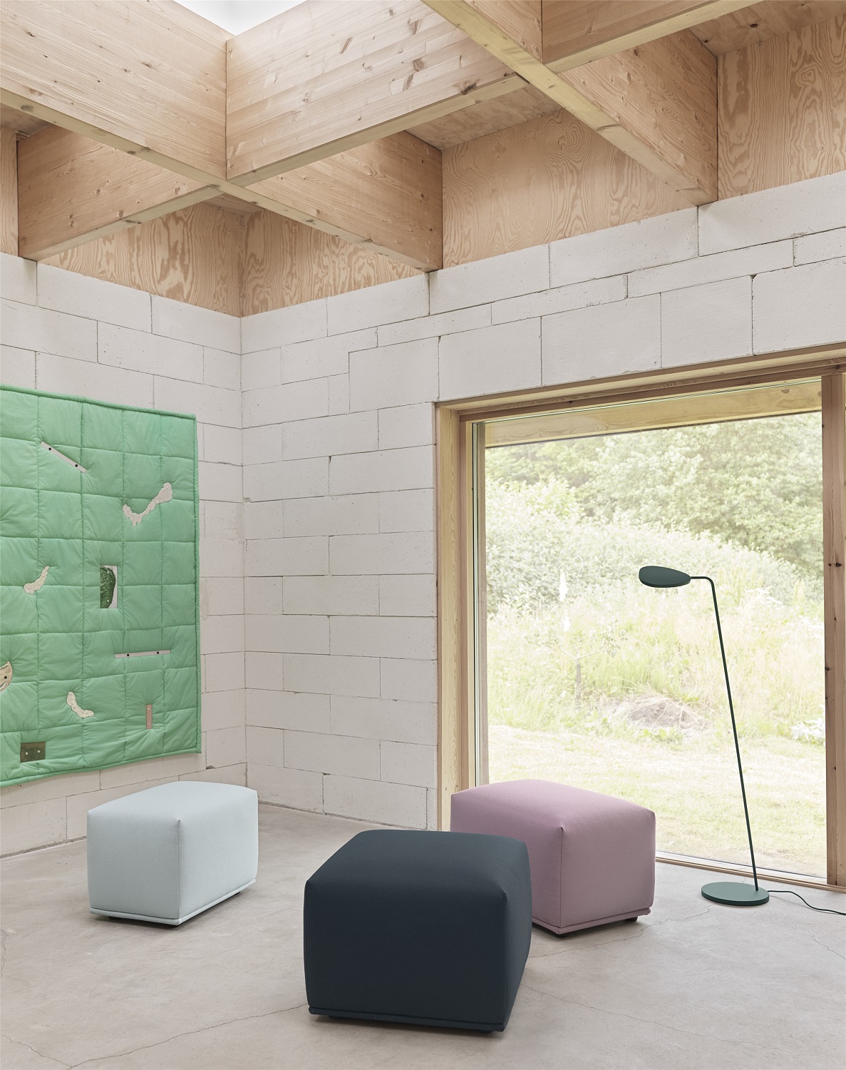 Drei farbige Muuto Pouf Hocker im Raum, moderne Sitzmöbel und stilvolle Wohnaccessoires.