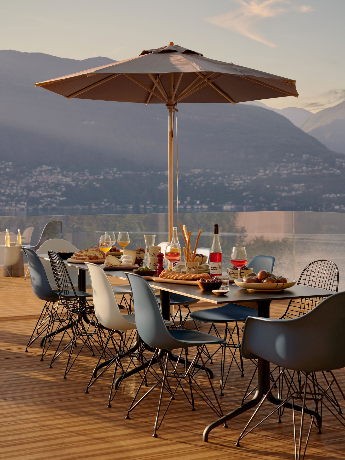 Esstisch im Freien mit Eames Plastic Armchair (DAR) Stühlen von Vitra, verschiedene Farben.