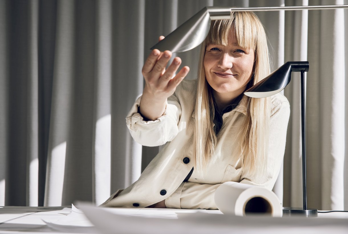 Frau mit MS Series Tischleuchte von Fritz Hansen in Schwarz und Aluminium.