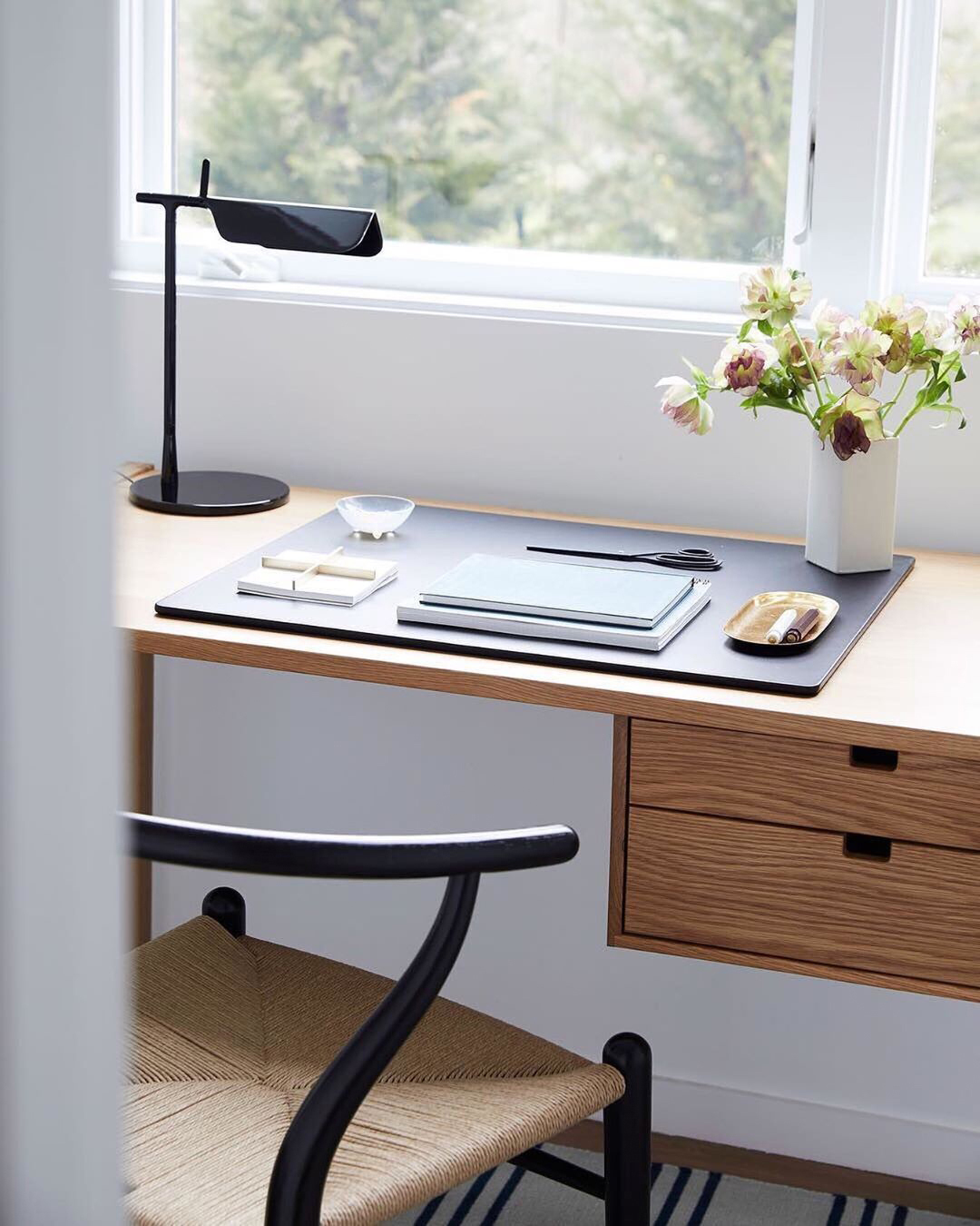 Schreibtisch mit Flos Tab LED Tischleuchte in Schwarz, moderne Arbeitsplatzbeleuchtung und stilvolles Design.