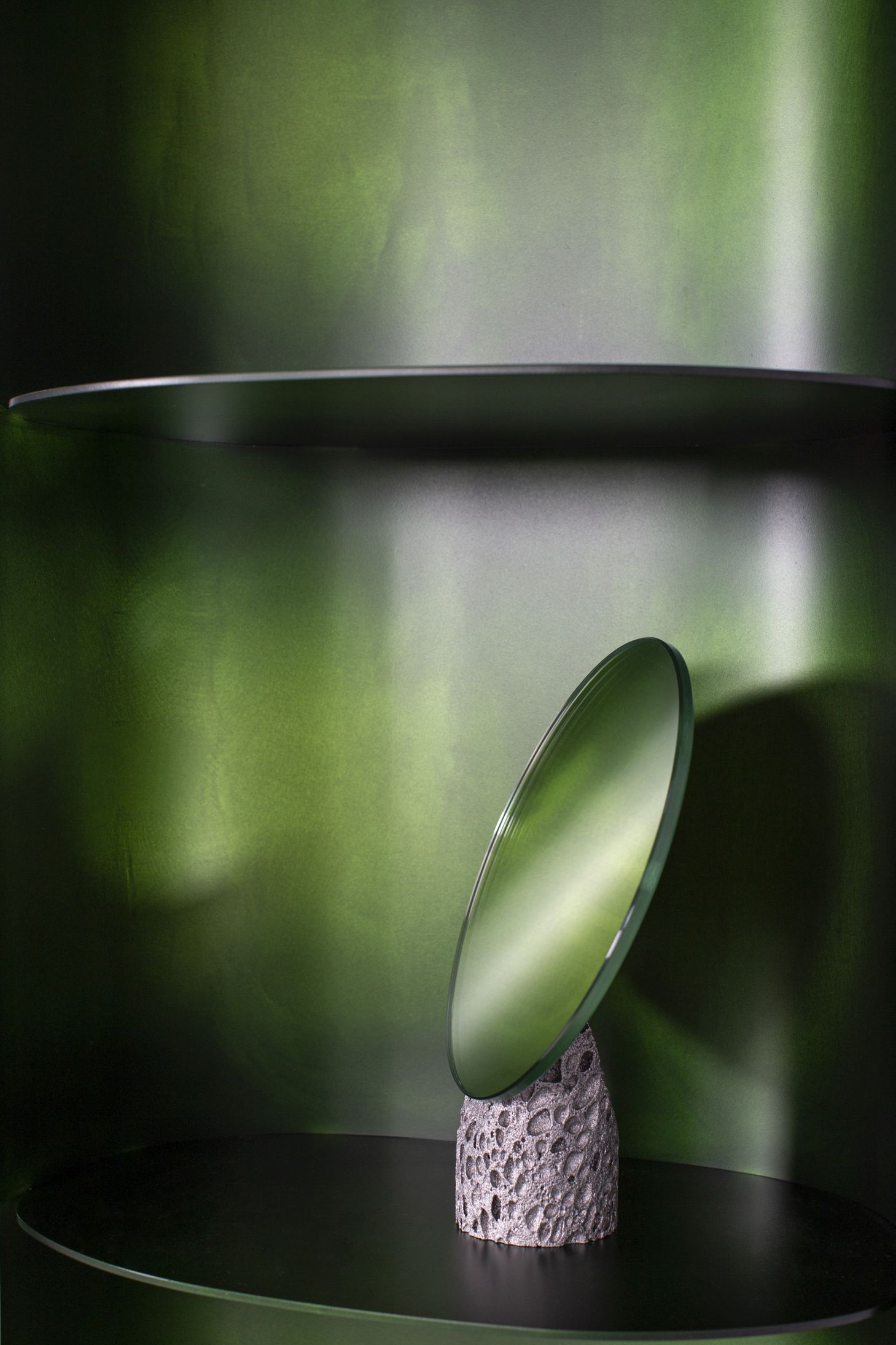 Como Regal Pulpo Dekoration: Runde Glasscheibe auf einem porösen Steinsockel.