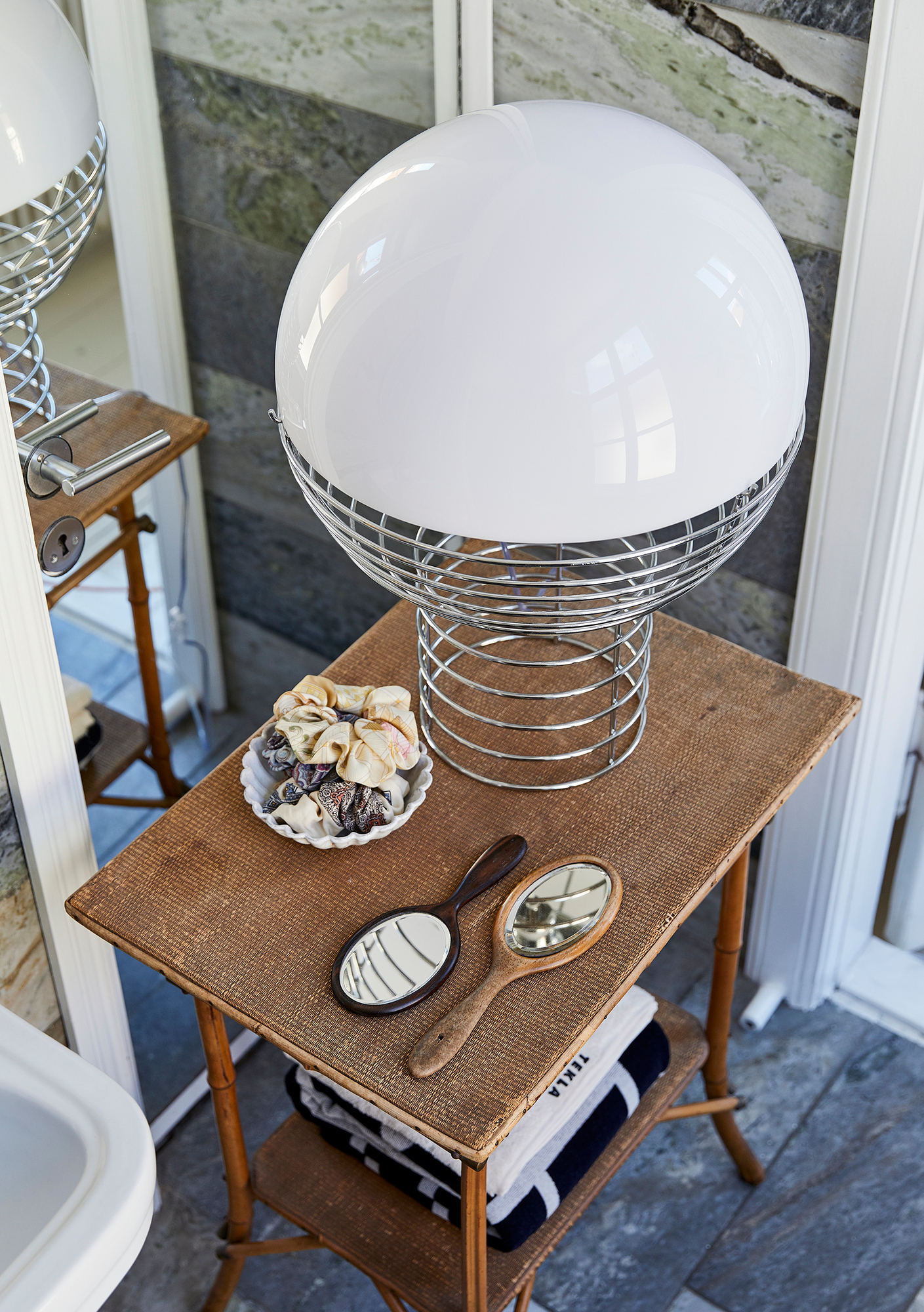 Verpan Wire Large Tischleuchte mit weißem Lampenschirm auf einem Beistelltisch im Badezimmer.