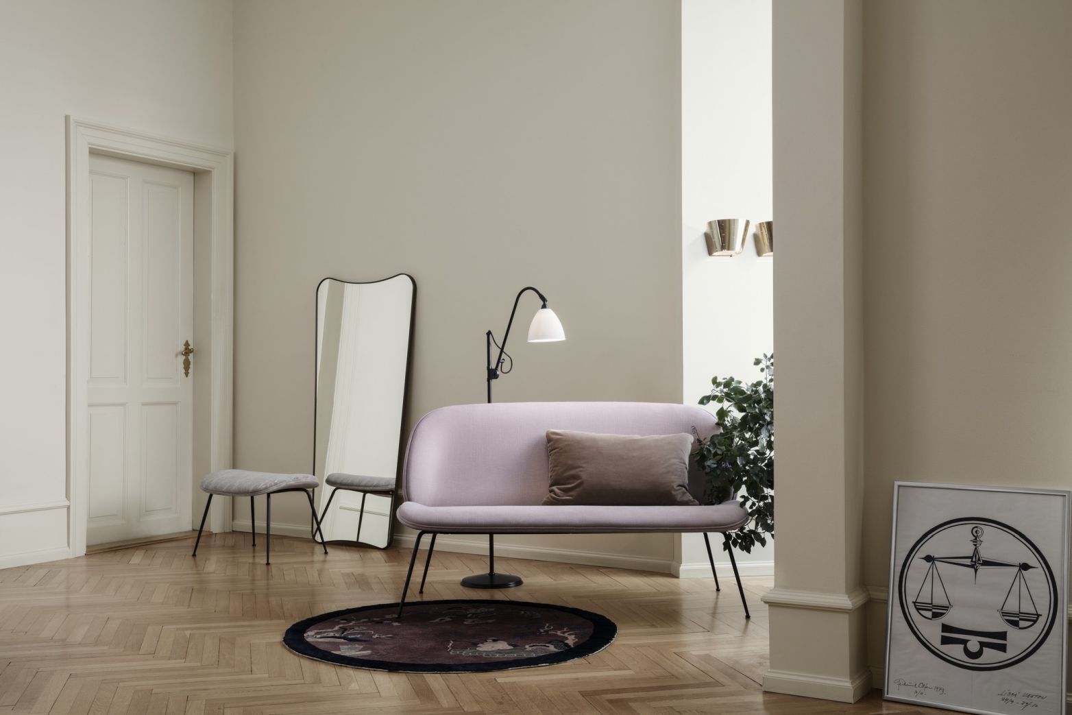 F.A. 33 Wandspiegel von Gubi in Messing, großer Spiegel im Interieur mit Sofa und Lampe.