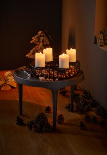 Panama Adventskranz von Philippi mit vier brennenden Kerzen in einem dunklen Metallkorb auf einem Tisch.