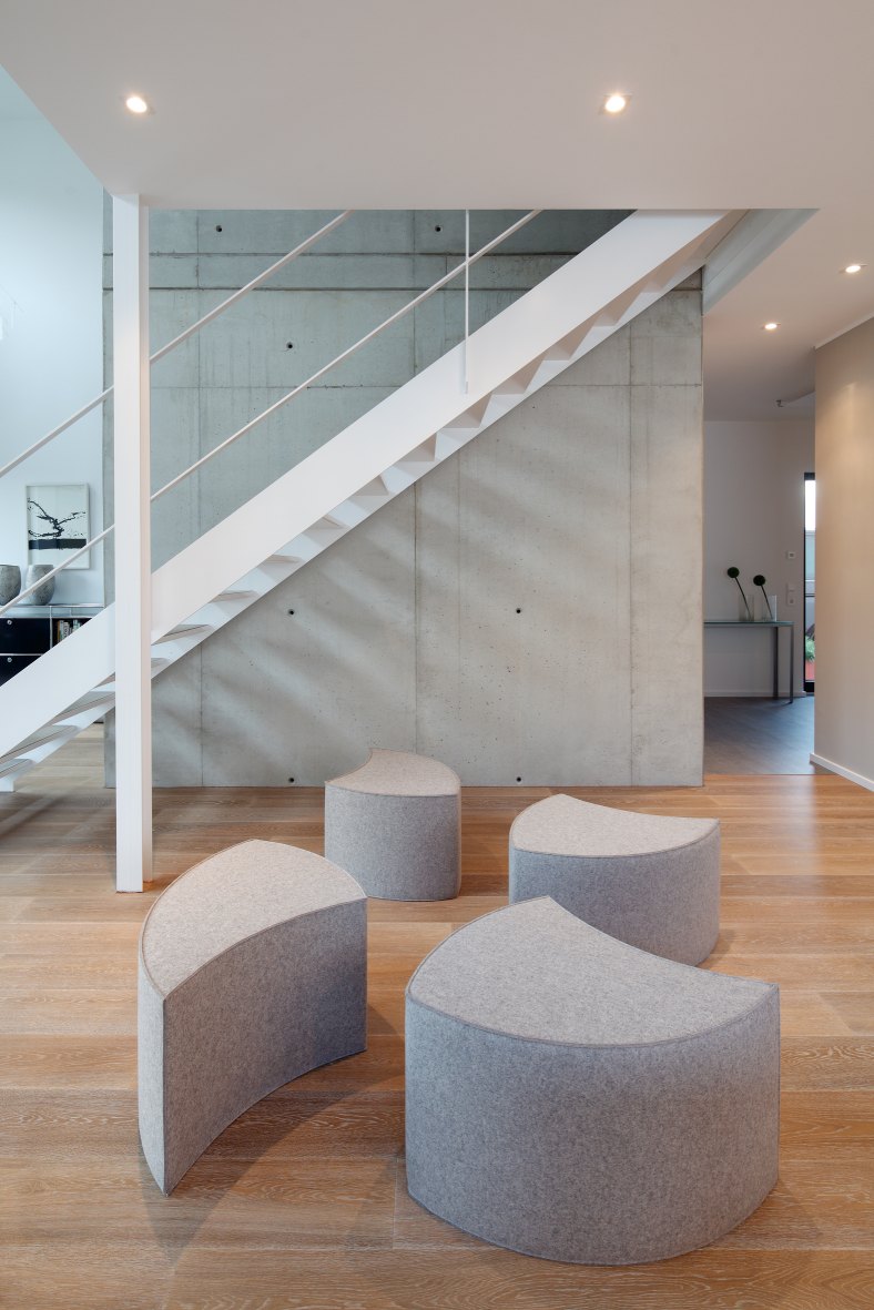 Graue Posito Sitzmöbel von Hey Sign aus Filz im modernen Wohnraum unter Treppe.