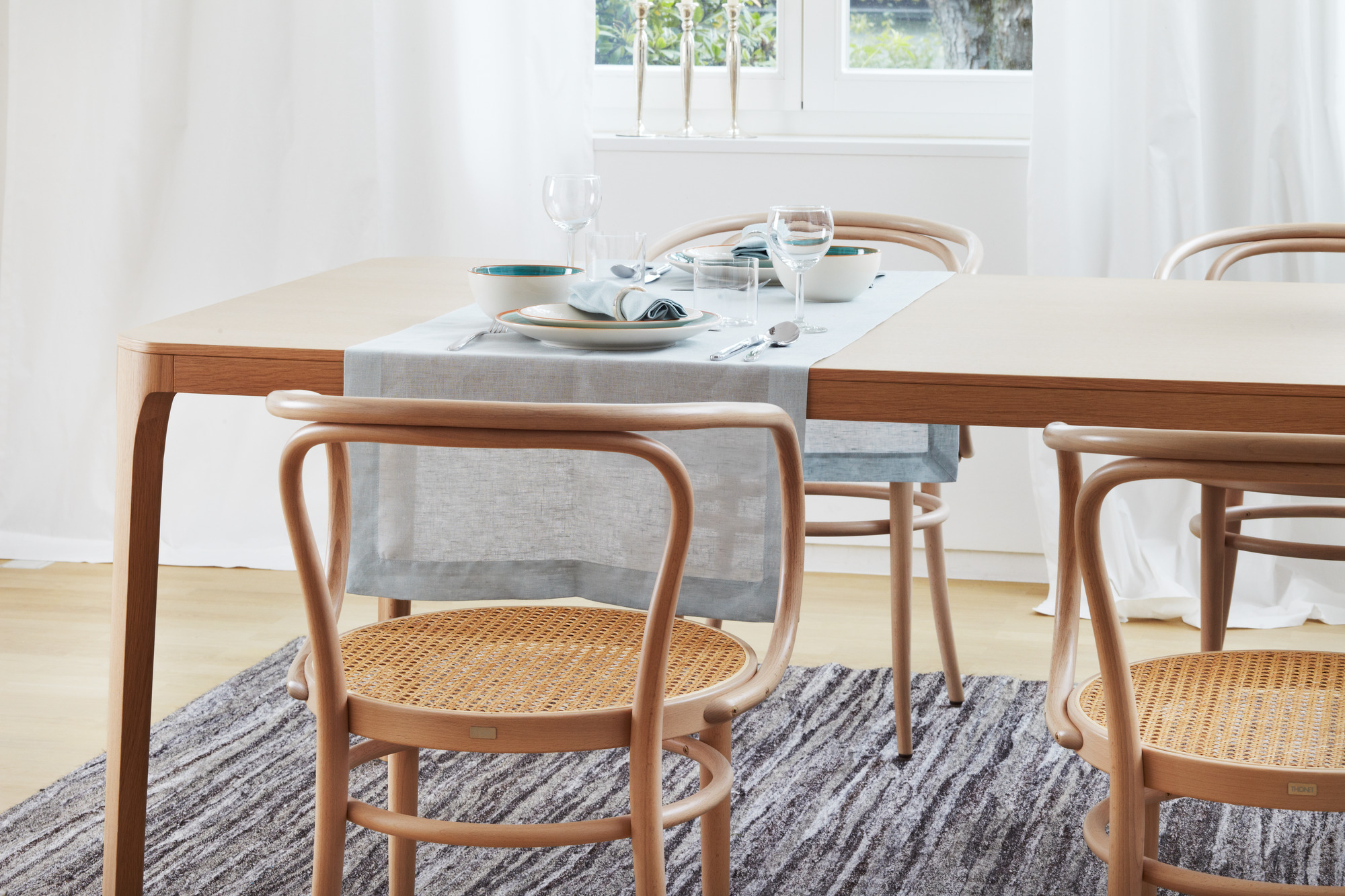 Bugholzstuhl Thonet 209 mit Wiener Geflecht vor Esstisch mit Geschirr und Dekoration.