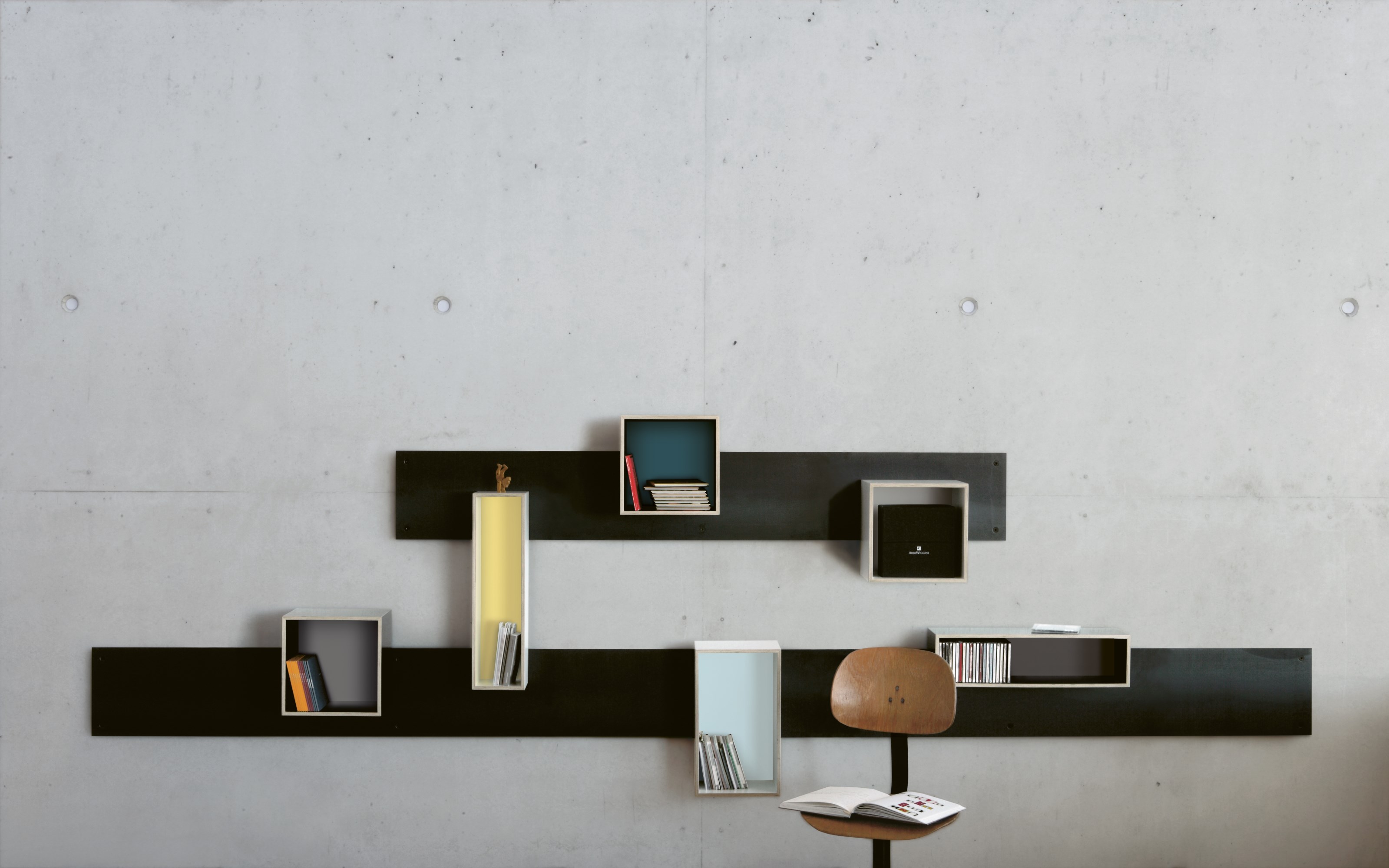 Magnetique Regal von Moormann: Wandregal mit magnetischen Elementen und farbigen Fächern an Betonwand.