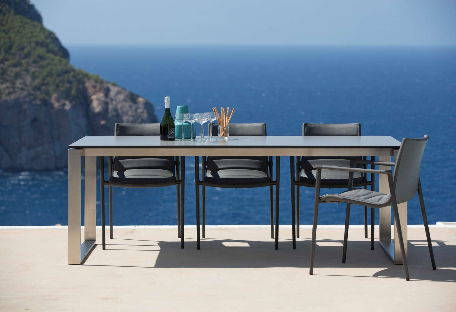 Cane-Line Core Outdoor Stuhl AirTouch mit Esstisch und Meerblick, graue Gartenmöbel.