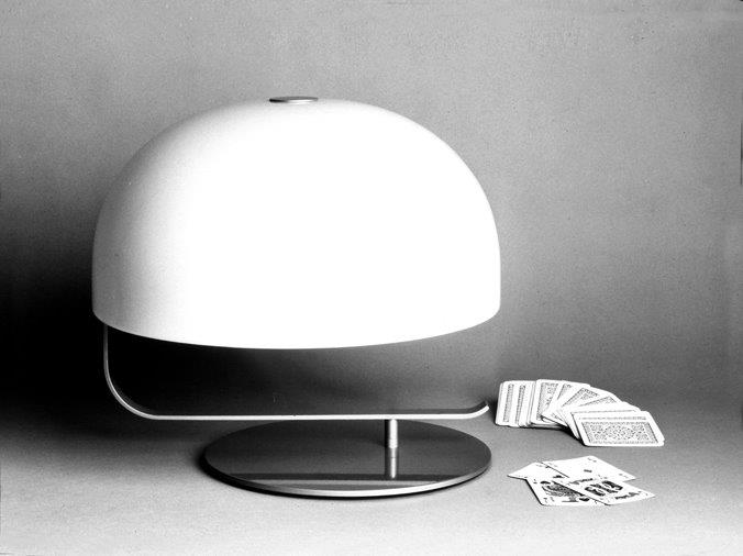 Schwarz-Weiß-Foto der Zanuso Tischleuchte Oluce mit weißem Lampenschirm und Spielkarten daneben.