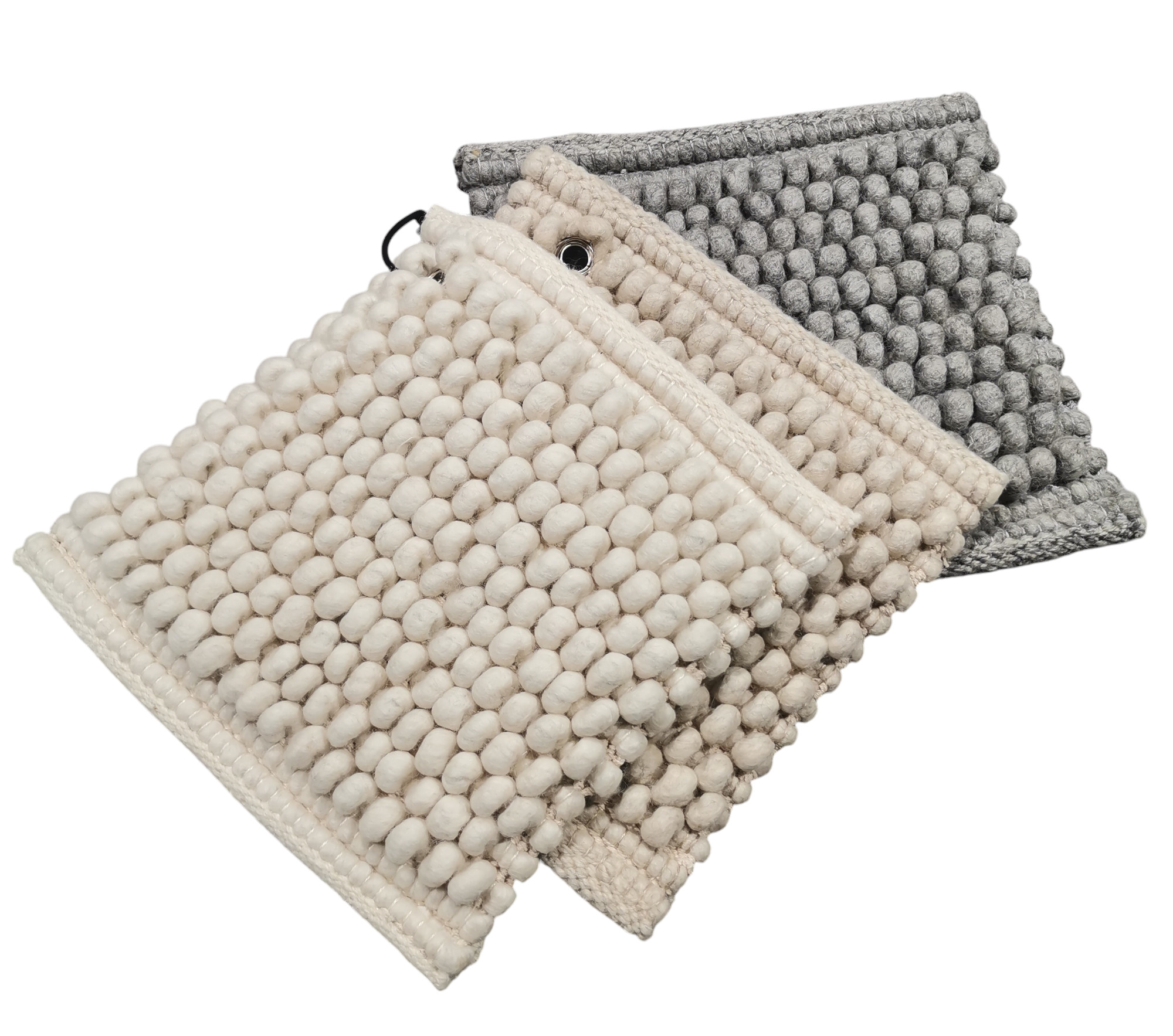 Nahaufnahme von drei Peas Teppichen in Grau, Beige und Weiß mit Noppenmuster.