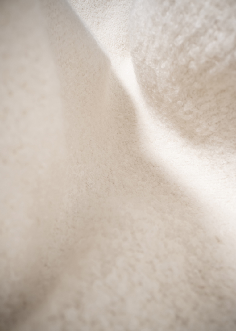 Detailaufnahme des elfenbeinfarbenen Pacha Ottoman Bezugs. Textur des luxuriösen Hockers.