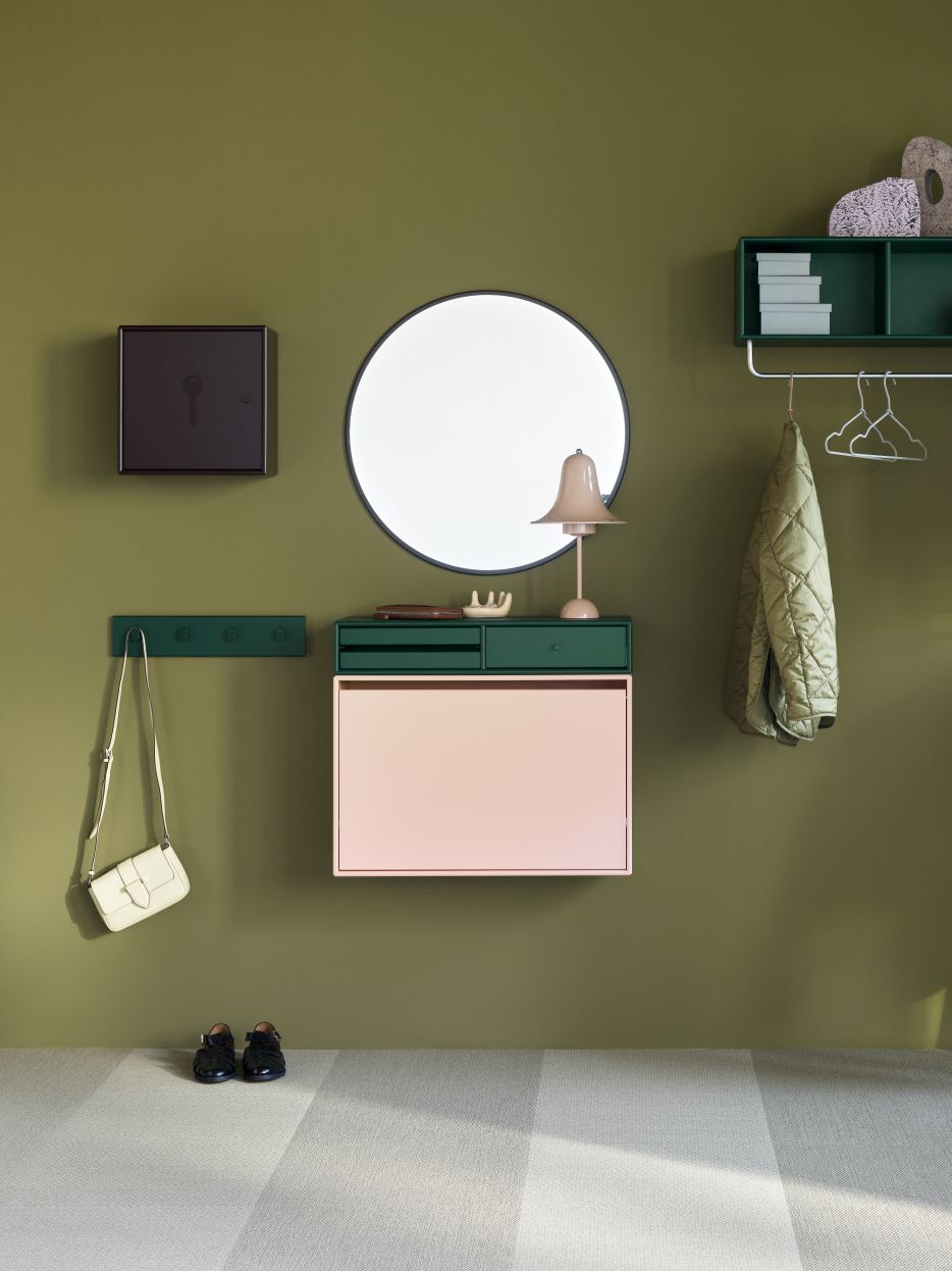 Unlock Schlüsselschrank Fennel Montana an grüner Wand mit Spiegel, Lampe, Garderobe und Accessoires.