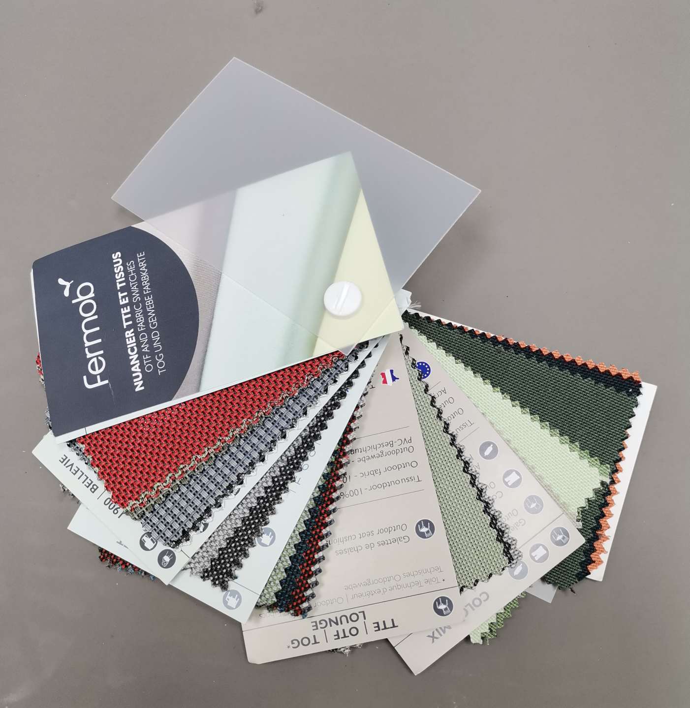 Farbmuster Farbkarte von Fermob: Nahaufnahme von Stoffmustern in verschiedenen Farben und Texturen.