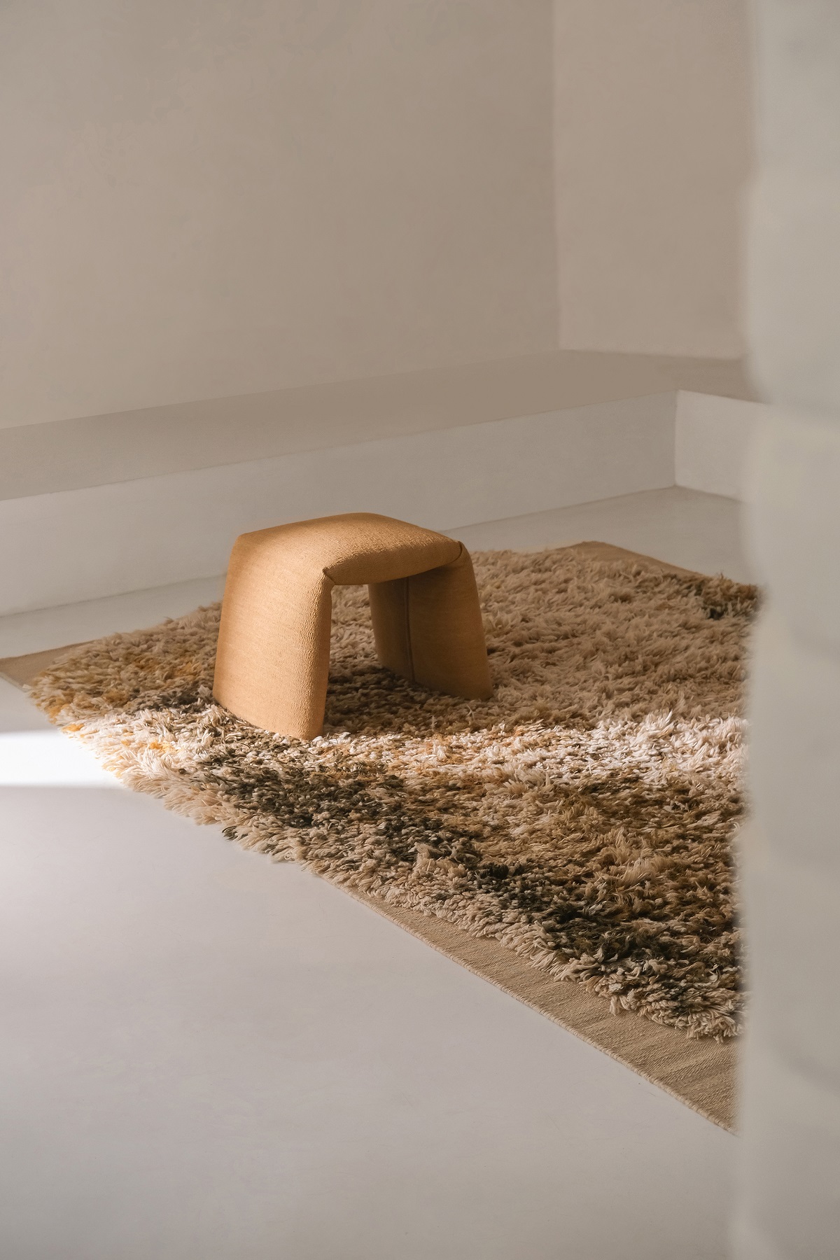 Safranrote Folded Colors Bank von Nanimarquina auf einem beigen Teppich, minimalistisches Design.