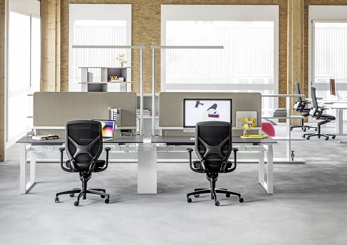Büroarbeitsplätze mit Schreibtischen, Bürostühlen und der XT-A Plus Stehleuchte in Grau für moderne Bürobeleuchtung.