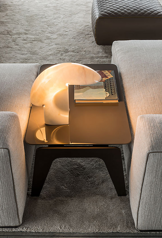 Nahaufnahme der beleuchteten Biagio Tischleuchte aus Marmor von Flos auf einem Beistelltisch.