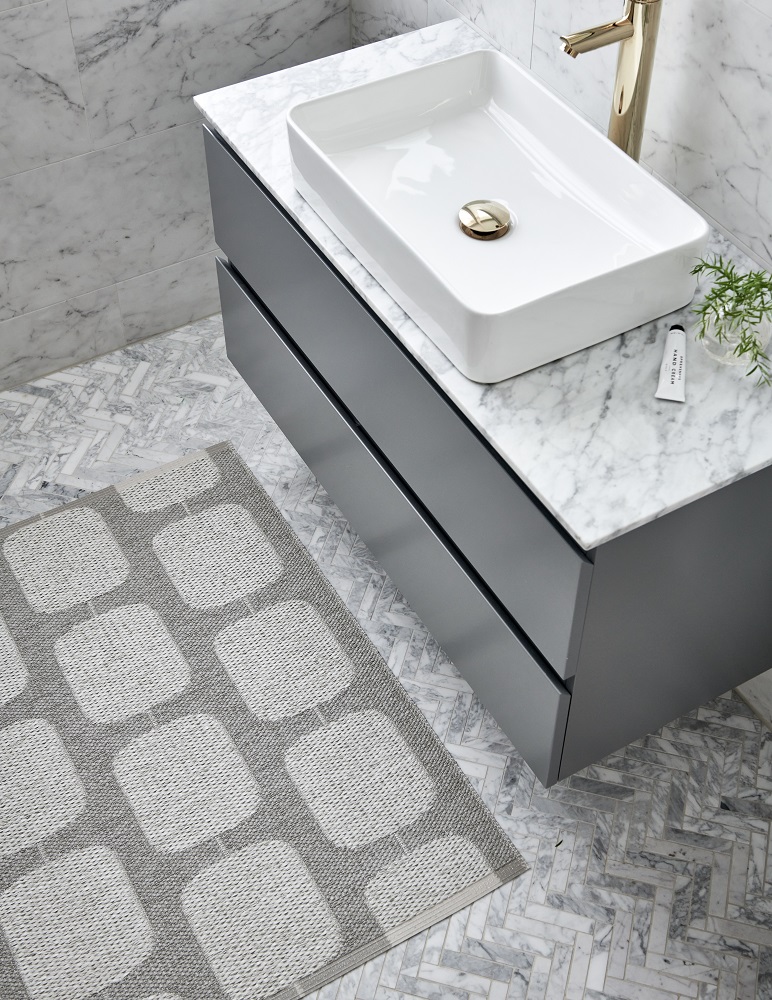 Sten Kunststoffteppich von Pappelina, 70x100 cm, Army/Fossil grau, mit grafischem Muster im Badezimmer.