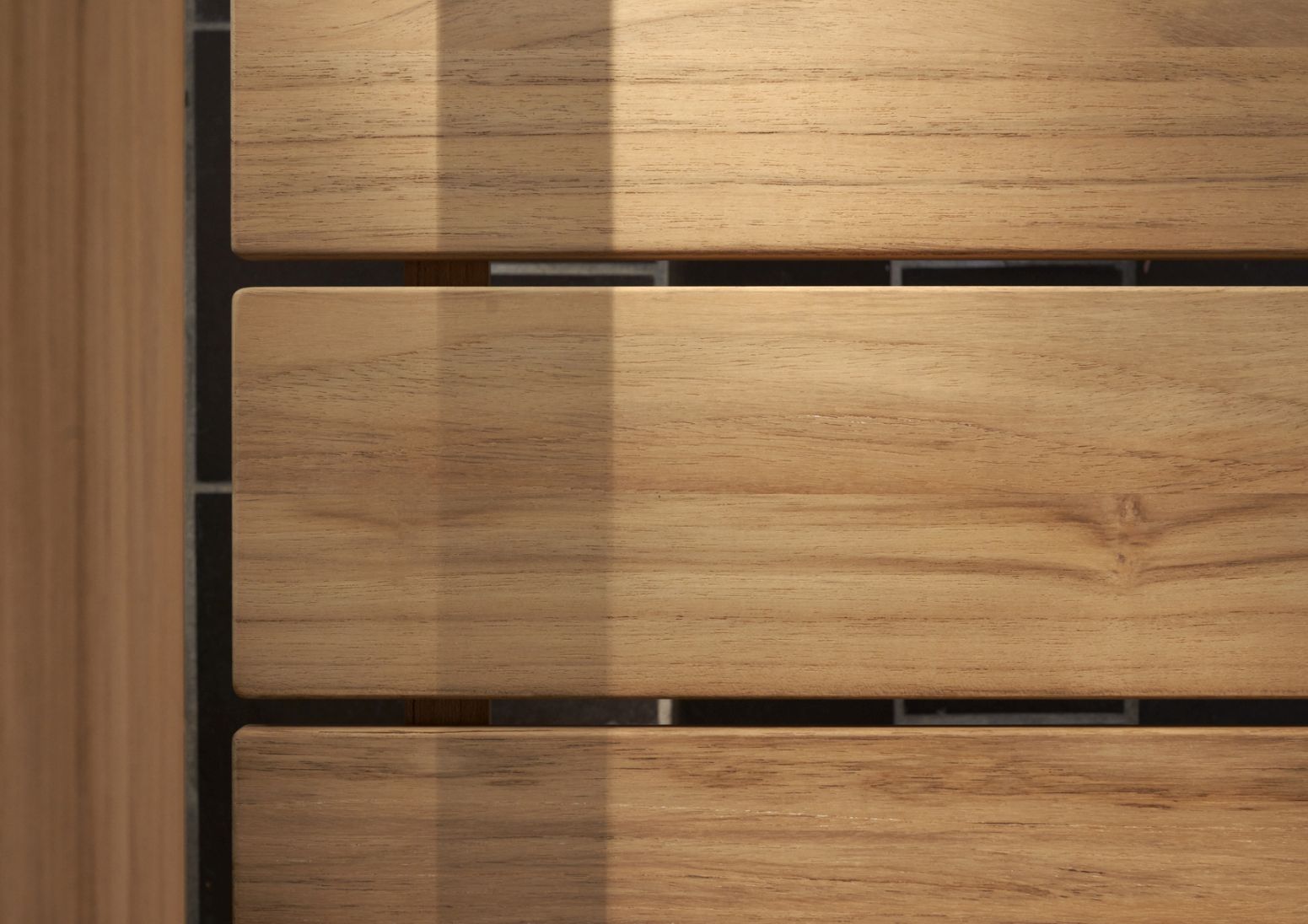 Detailaufnahme der GL101 Timbur Bank von Carl Hansen & Søn: Teakholz-Latten mit Schatten.