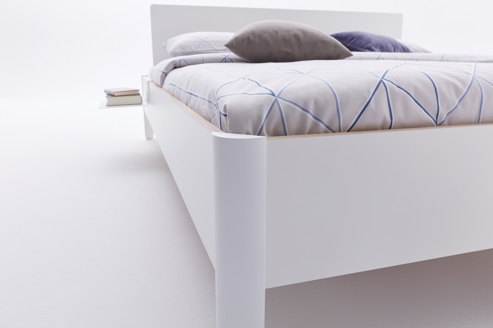Weißes Nait Bett von Müller Möbelwerkstätten mit Bettwäsche und Nachttisch im minimalistischen Design.