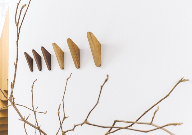 Schönbuch Cut Wandhaken aus Holz in verschiedenen Farben an einer weißen Wand.