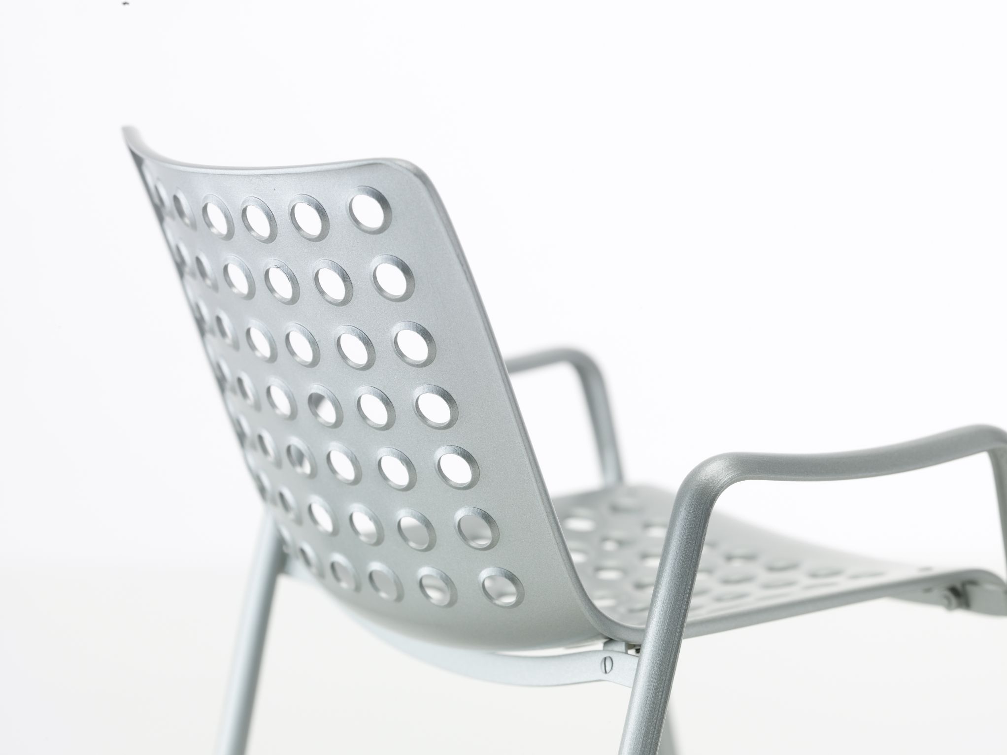 Silberner Landi Stuhl mit Armlehnen und Lochmuster, Designklassiker für Garten und Terrasse.