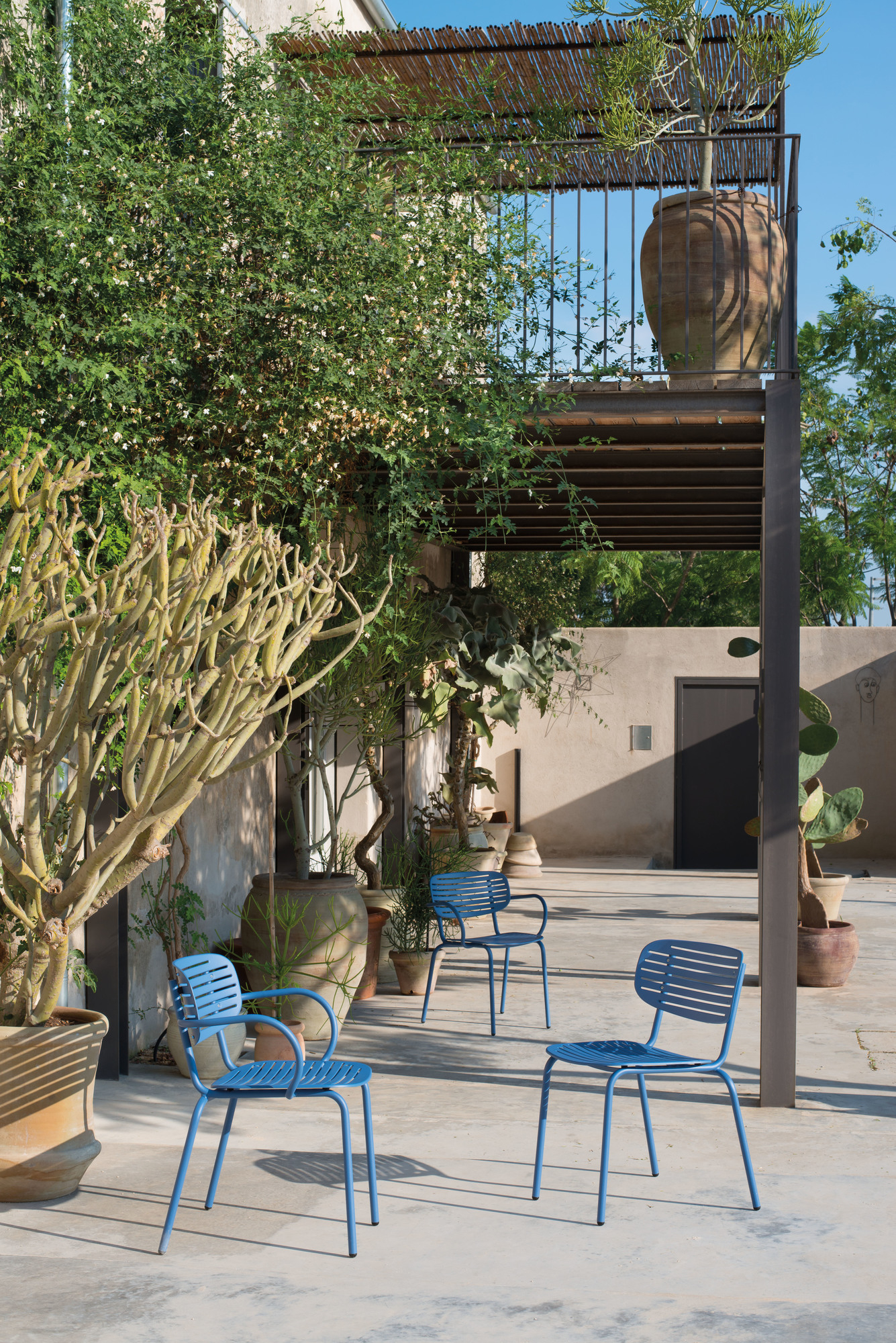 Drei blaue Emu Stühle im Außenbereich, Gartenmöbel für Terrasse und Balkon.