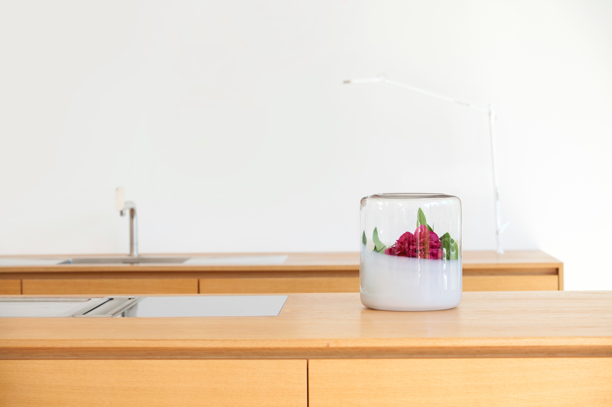 Glasvase mit roten Blumen auf einem Holztisch, Dekoration für Zuhause. Glasgow Vase.