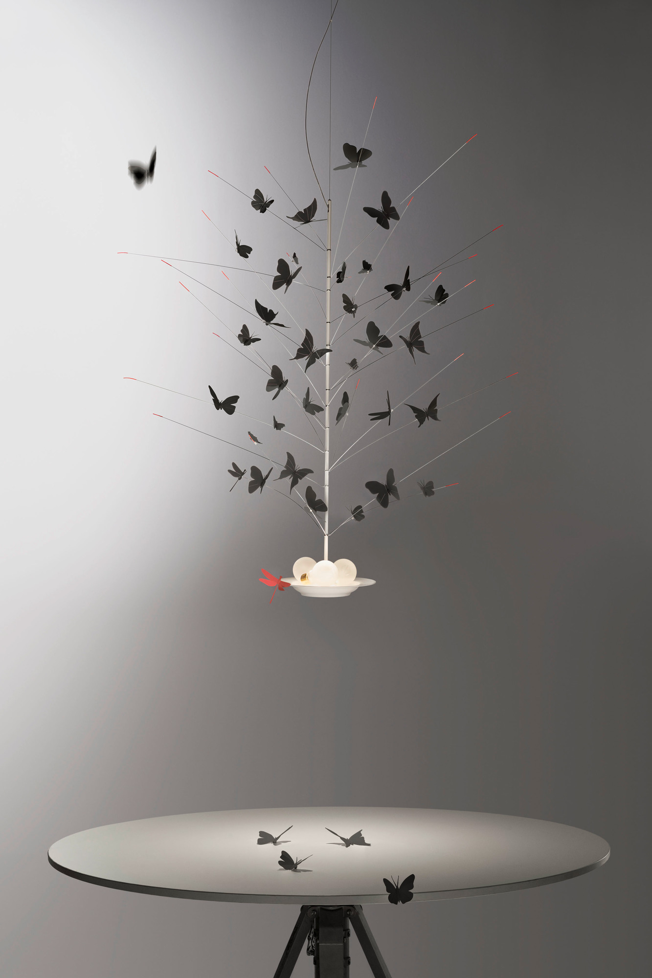 Detailaufnahme der Ingo Maurer "Farfalle" Deckenleuchte mit vielen schwarzen Schmetterlingen und roter Libelle.