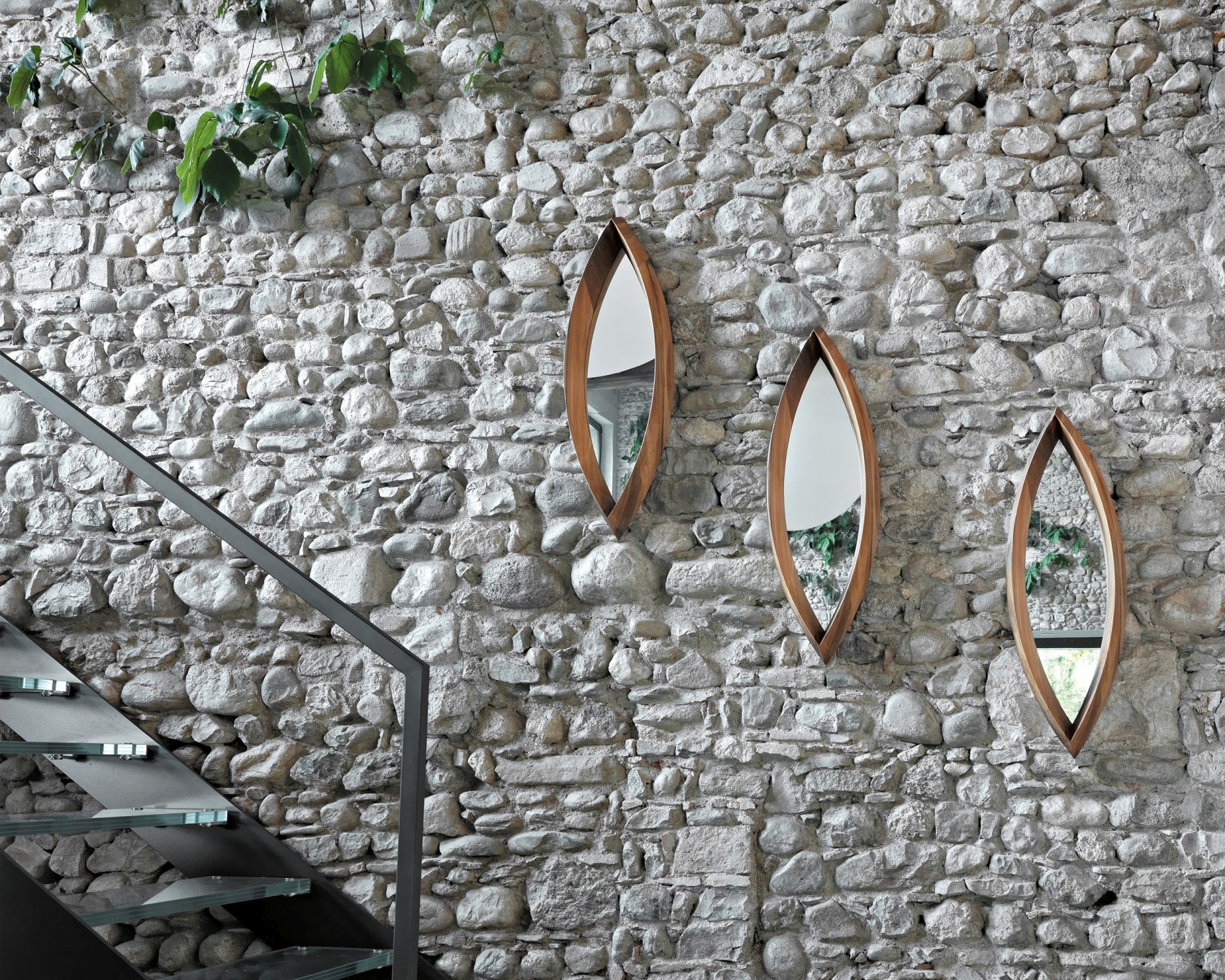 Drei Mamanonmama Spiegel mit Holzrahmen an Steinwand, modernes Design für Flur oder Wohnzimmer.