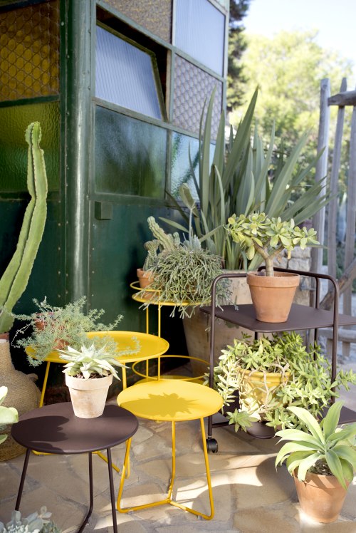 Nahaufnahme von Cocotte Beistelltischen von Fermob in Gelb und Braun, Outdoor-Möbel für Garten und Terrasse.