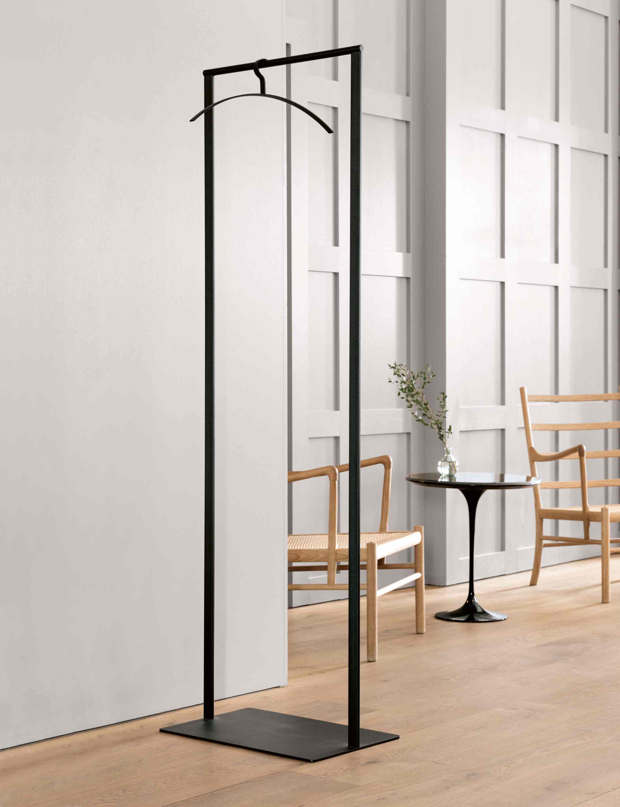 Schlanker, schwarzer Schönbuch Garderobenständer mit Kleiderbügel im modernen Interieur. Stehende Garderobe für Flur und Diele.