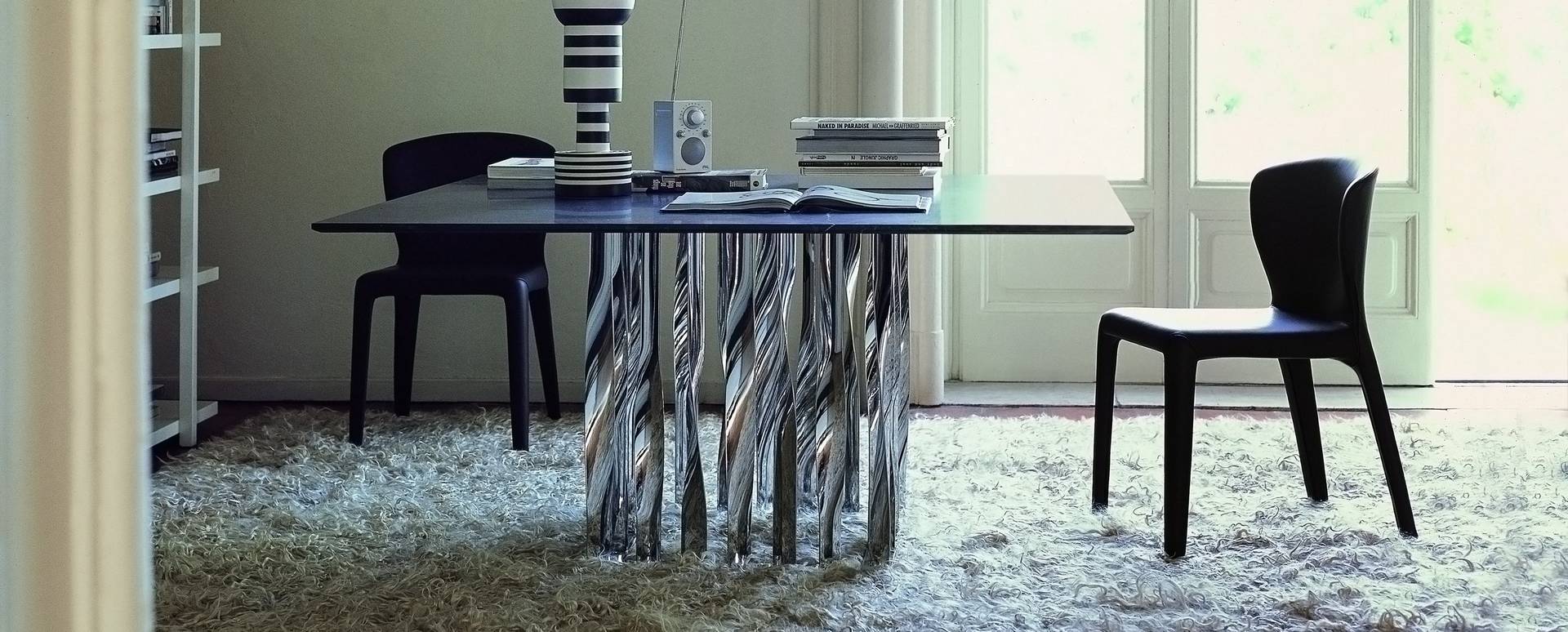 Schwarzer 369 Hola Stuhl von Cassina am Esstisch mit verchromtem, skulpturalem Untergestell. Modernes Möbeldesign.