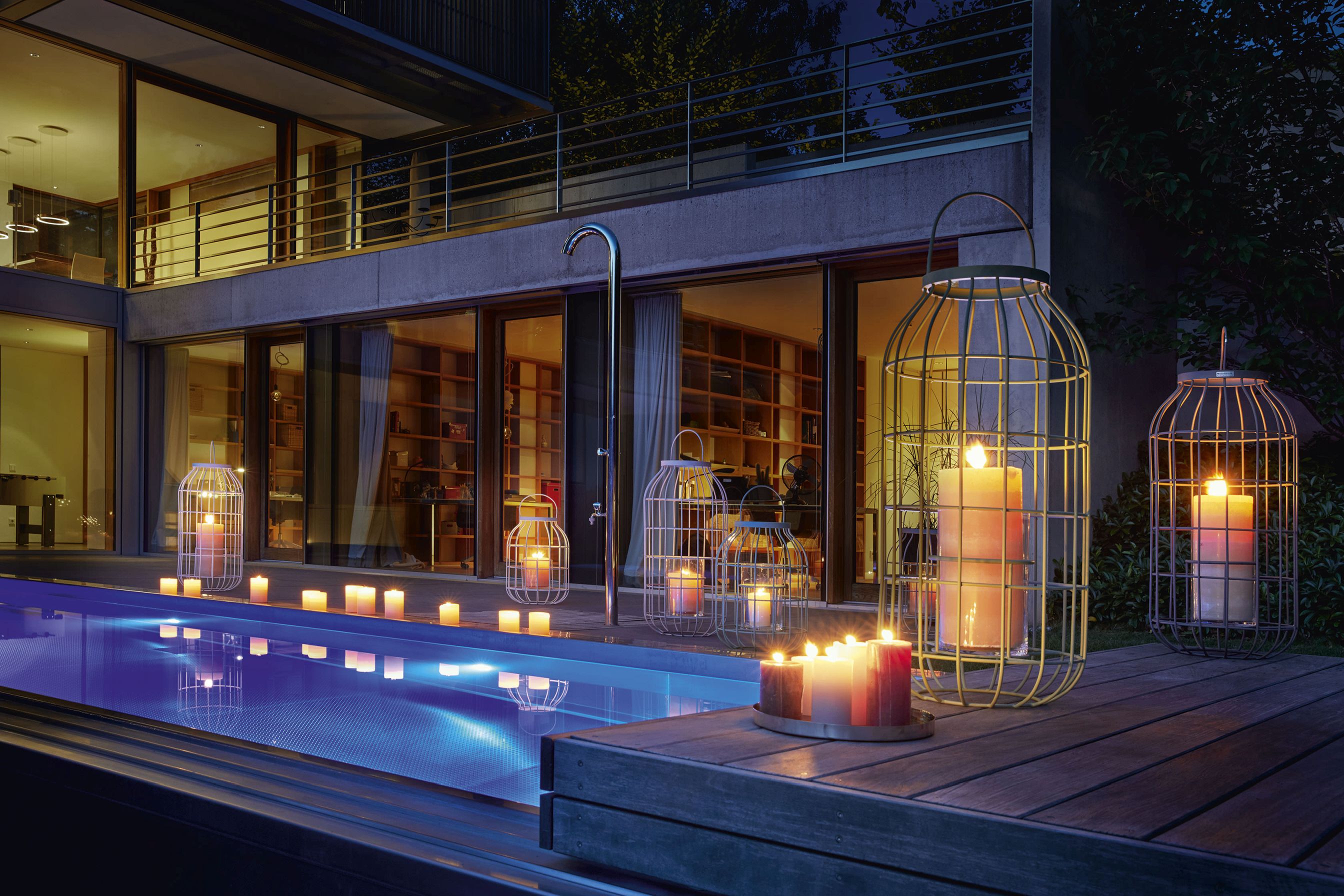 Weishäupl Laterne Outdoor neben Pool mit brennenden Kerzen für stimmungsvolle Gartenbeleuchtung und Dekoration.