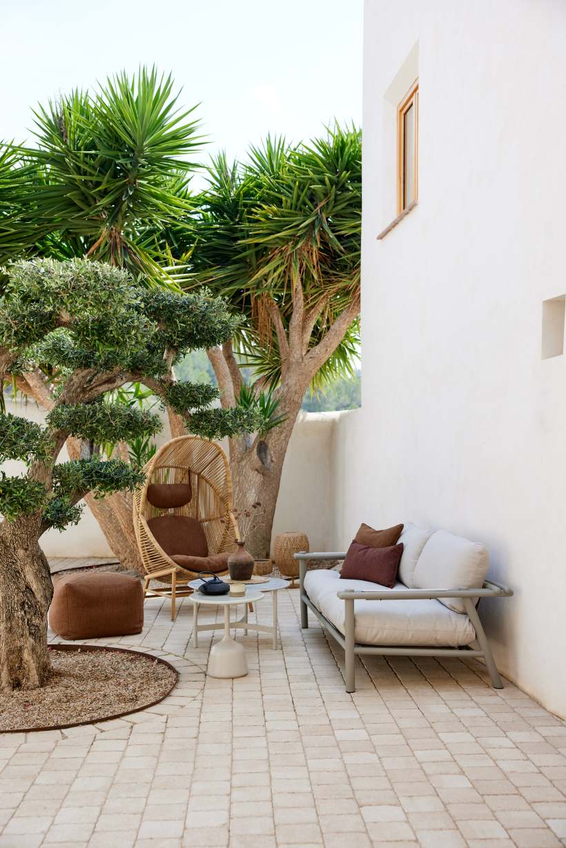 Gartenmöbel-Set mit Cane-Line Hive Sessel in Natur und Outdoor Sofa mit Kissen.