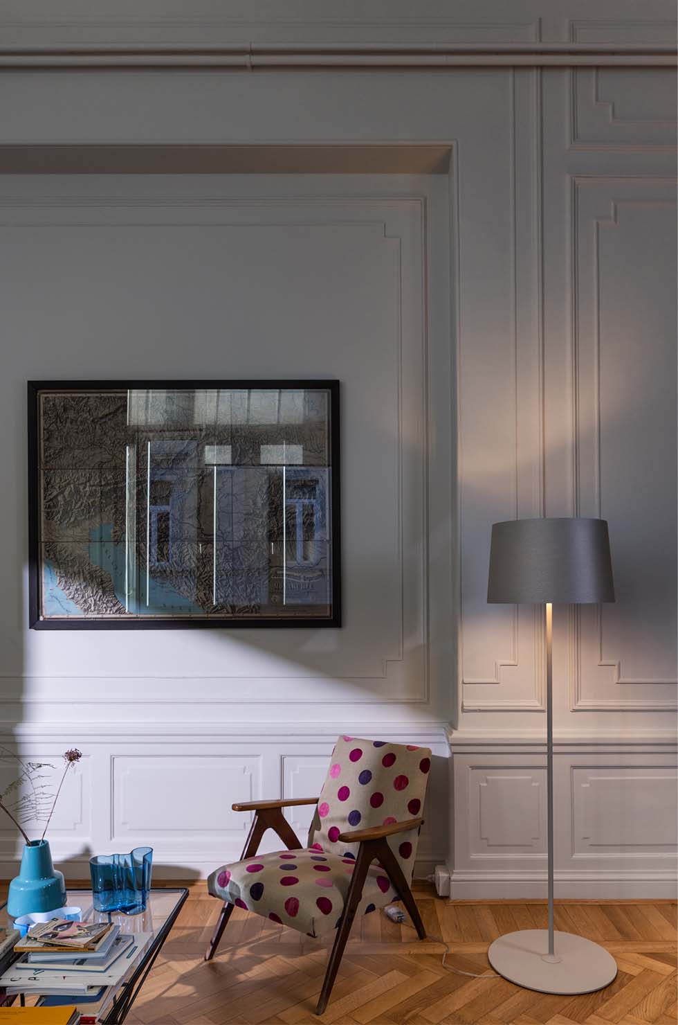 Moderne graue Twiggy Lettura Stehleuchte von Foscarini im Wohnzimmer mit Sessel und Kunstwerk.