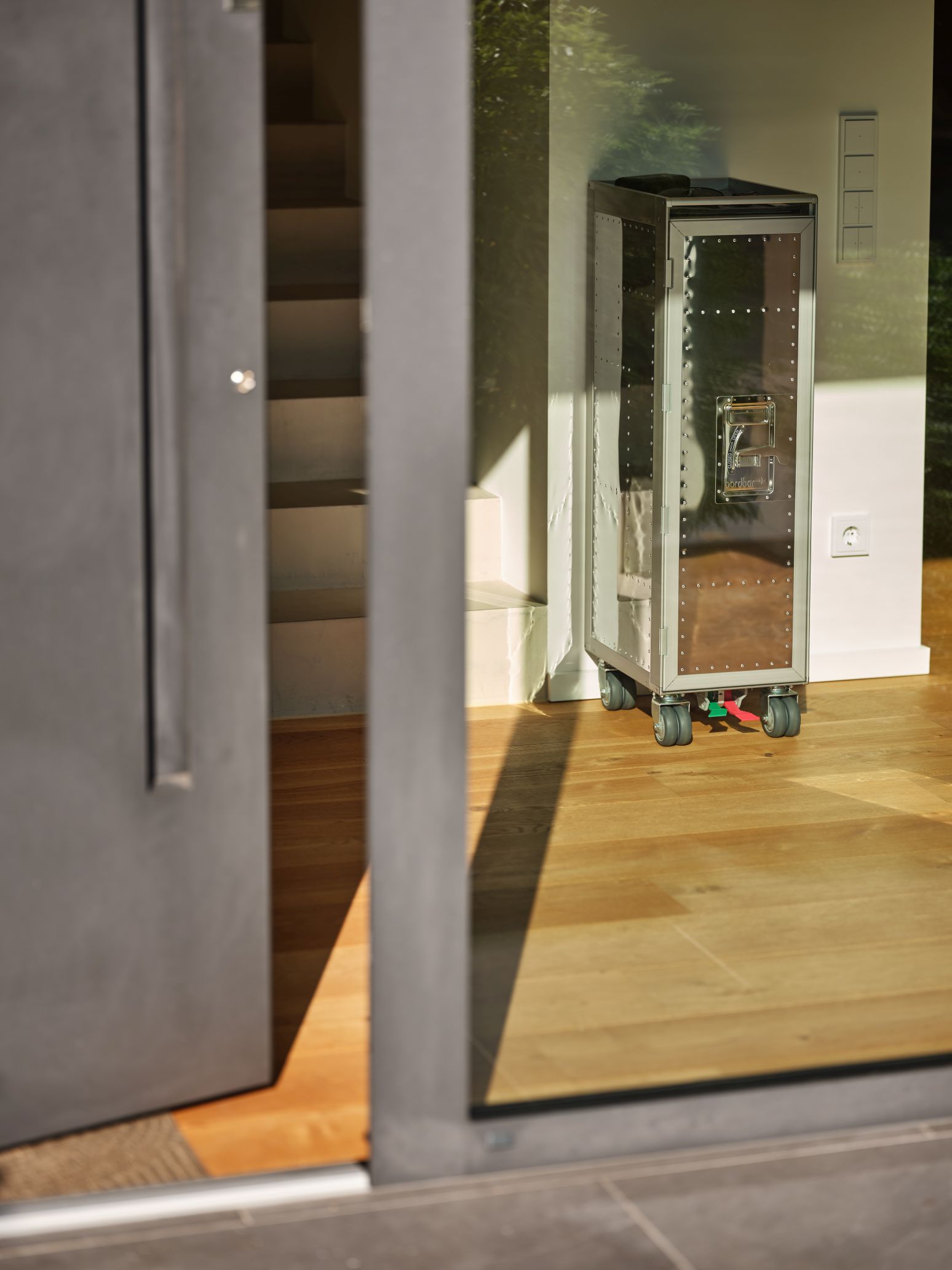 Rivet Rocker Flugzeugtrolley Bordbar mit Fenster, silberfarben, auf Holzfußboden, modernes Design.
