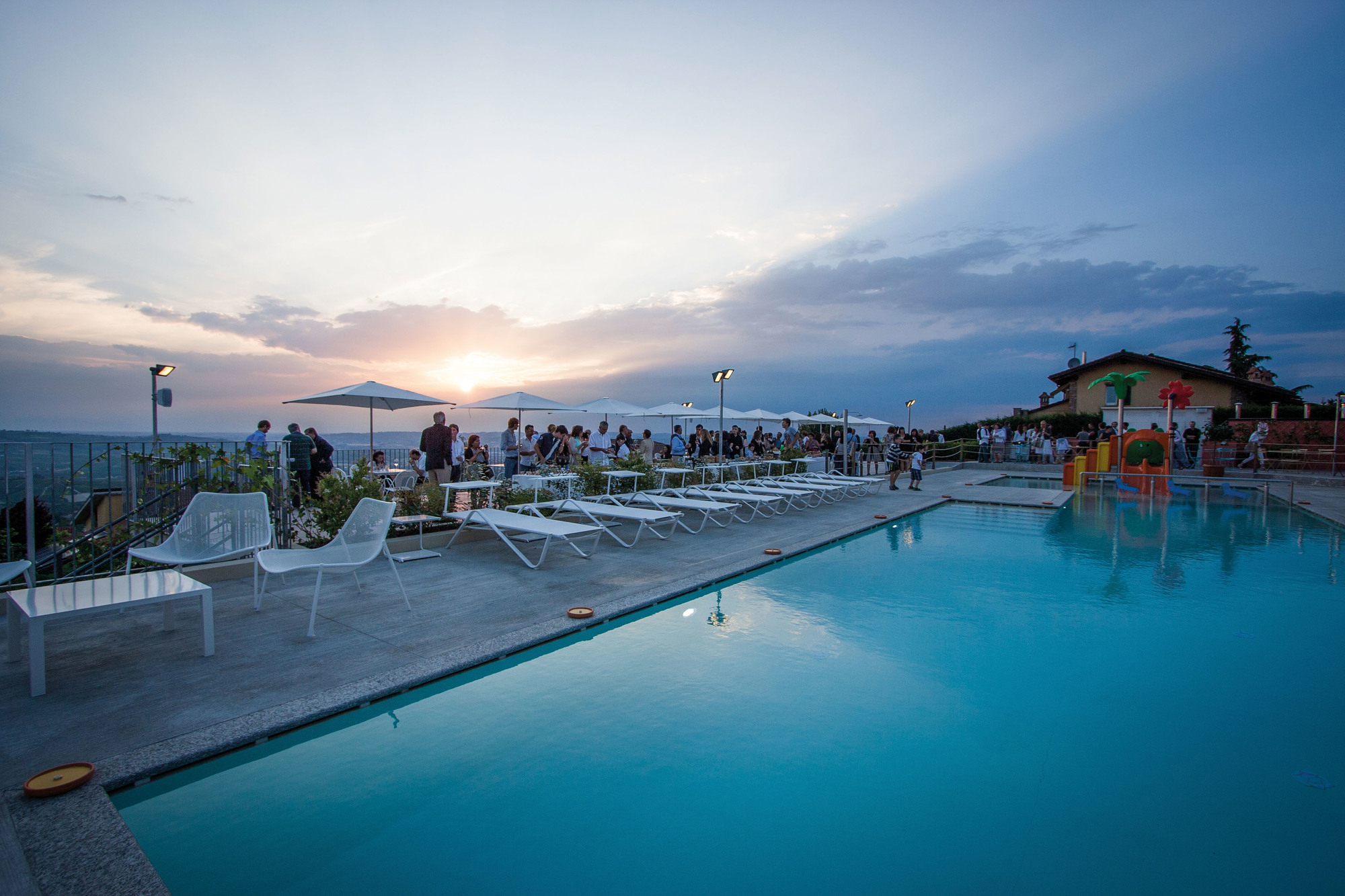 Weiße Emu Holly Sonnenliegen am Pool bei Sonnenuntergang, ideal für Garten und Terrasse.