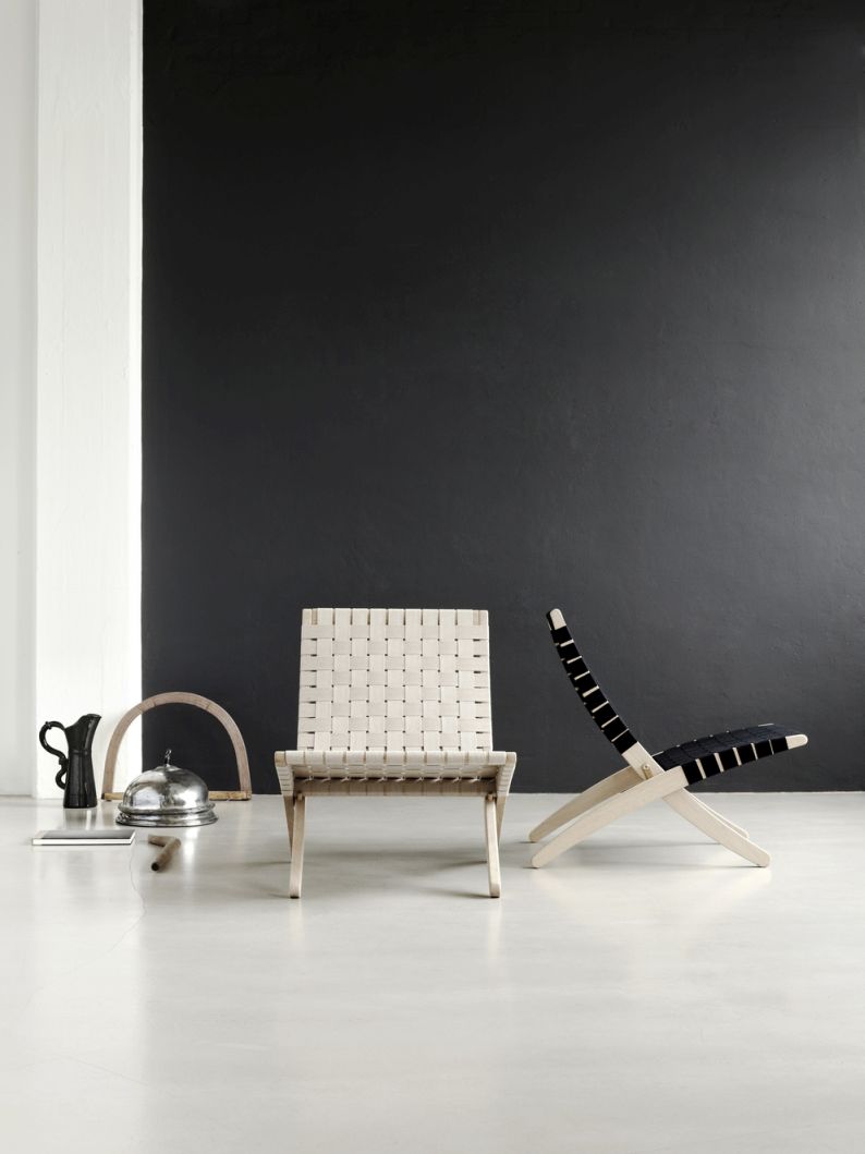 Cuba Chair Sessel: Zwei moderne Holzstühle mit geflochtenen Sitzflächen in hellem Interieur.