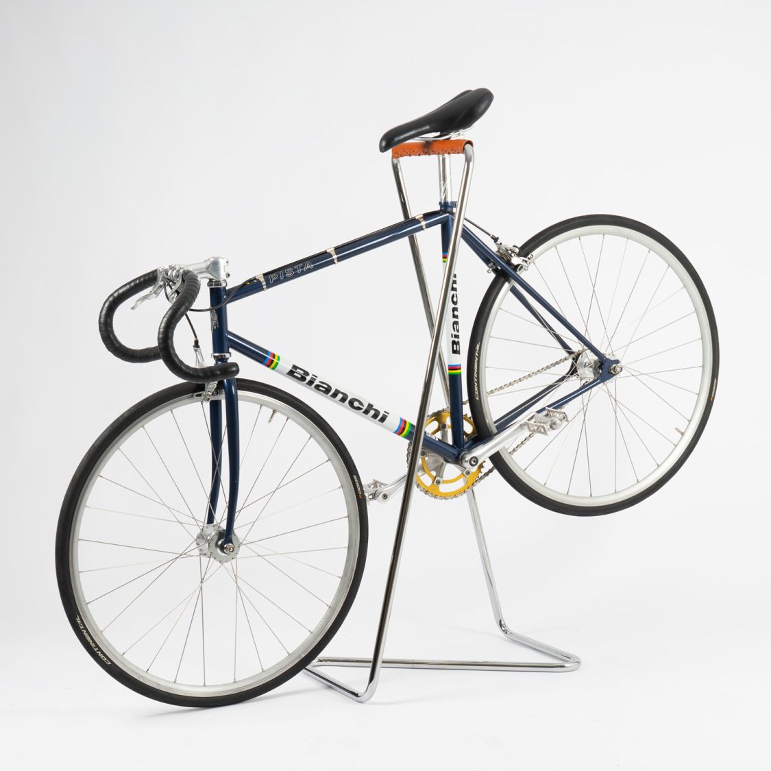 Z10 Fahrradständer aus Edelstahl mit Cognac Manschette von Tecta hält ein blaues Bianchi Rennrad.