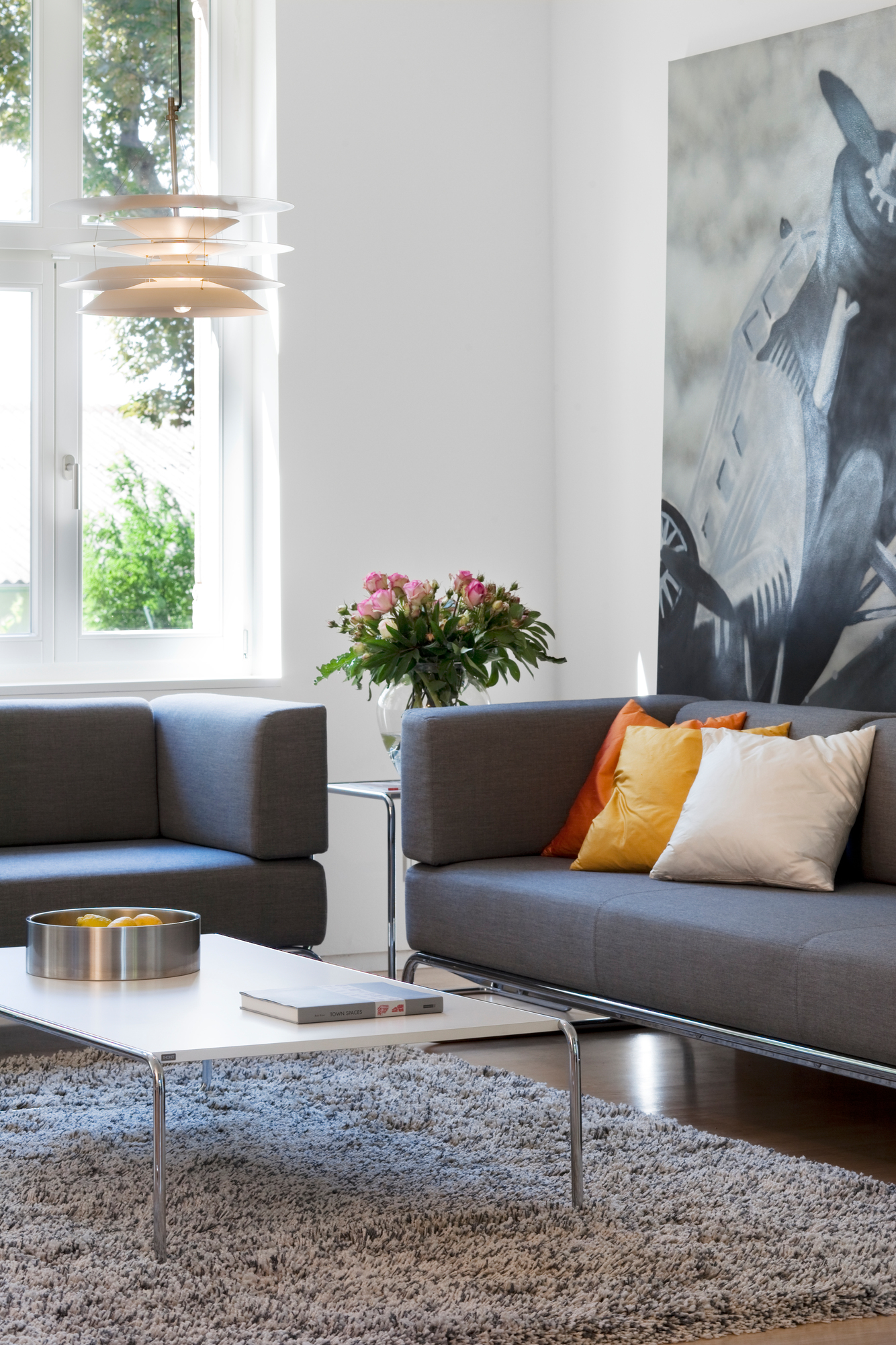 Wohnzimmer mit grauem Sofa, Teppich und Thonet S 5001 Sessel im modernen Design.