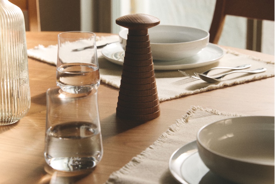 Nahaufnahme der Alessi Yucatan Salz- und Gewürzmühle aus Holz auf einem gedeckten Esstisch.