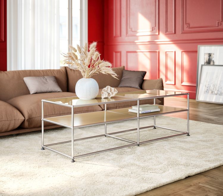 Moderner Couchtisch mit Glasplatten und Chromgestell im Wohnzimmer, dekoriert mit Vase und Büchern.